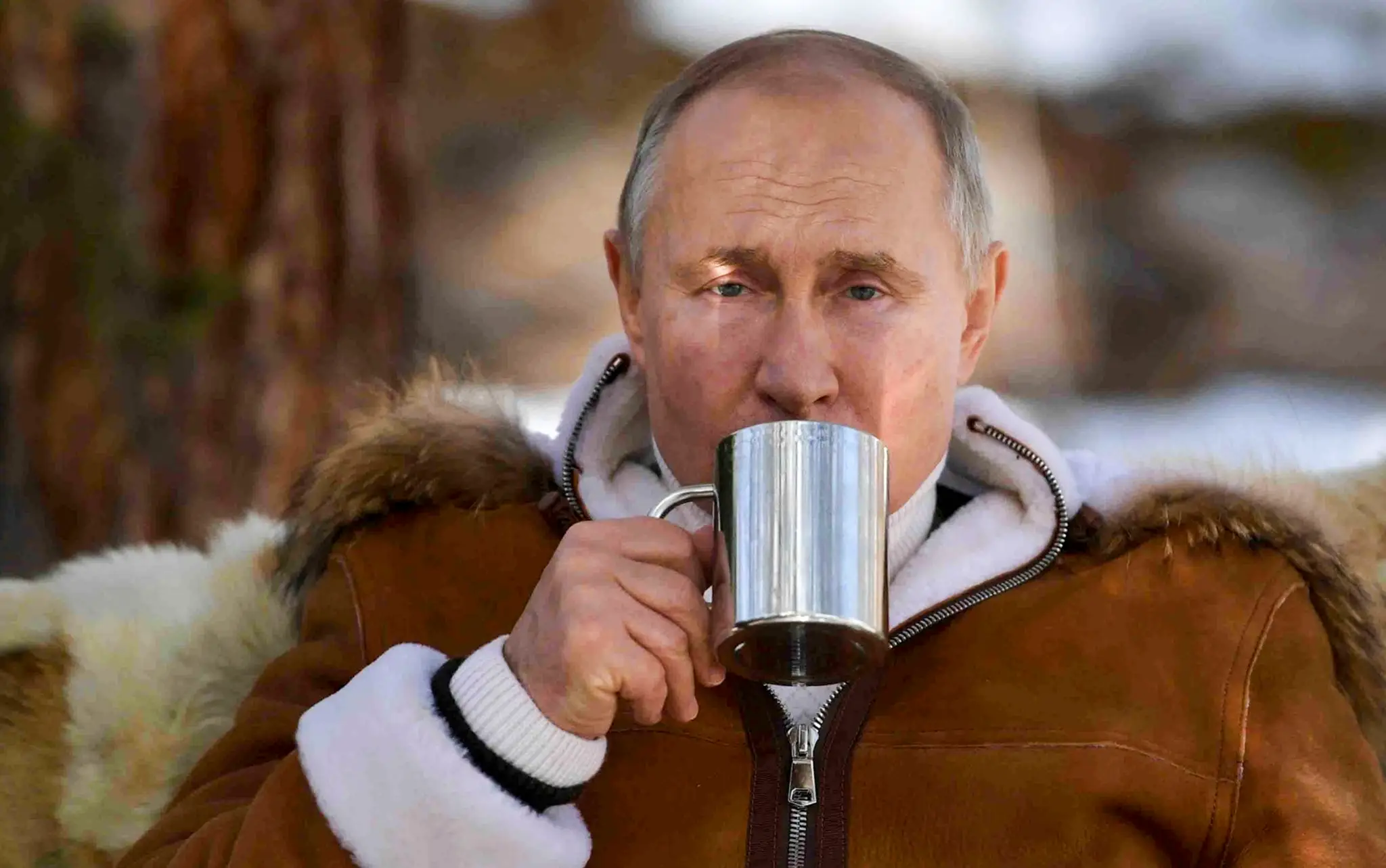 Ruský prezident Vladimir Putin pije zo šálky v rámci prestávky počas víkendovej návštevy tajgy na Sibíri.