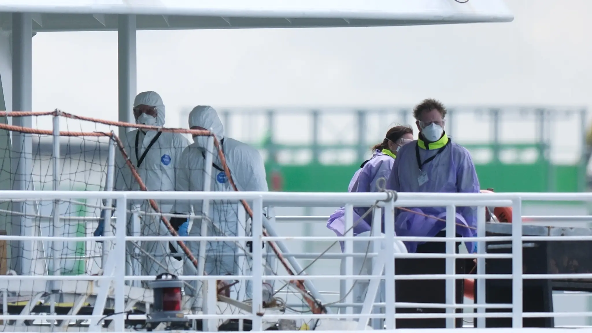 Posádka v ochranných pomôckach na výletnej lodi MV Hondius po jej príchode do rotterdamského prístavu.