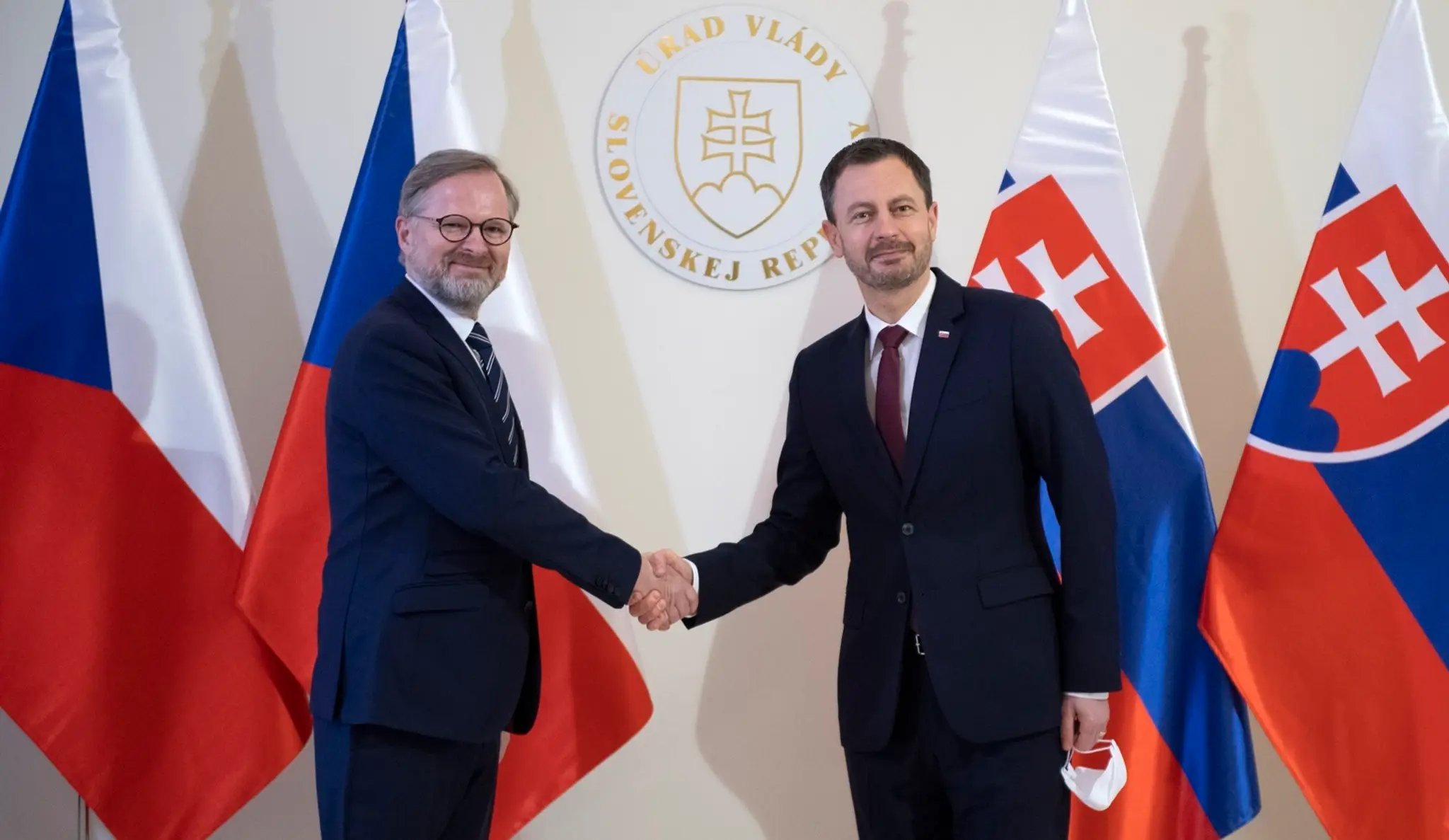 Na snímke nový český premiér Petr Fiala (vľavo) a slovenský premiér Eduard Heger (vpravo) si podávajú ruky.