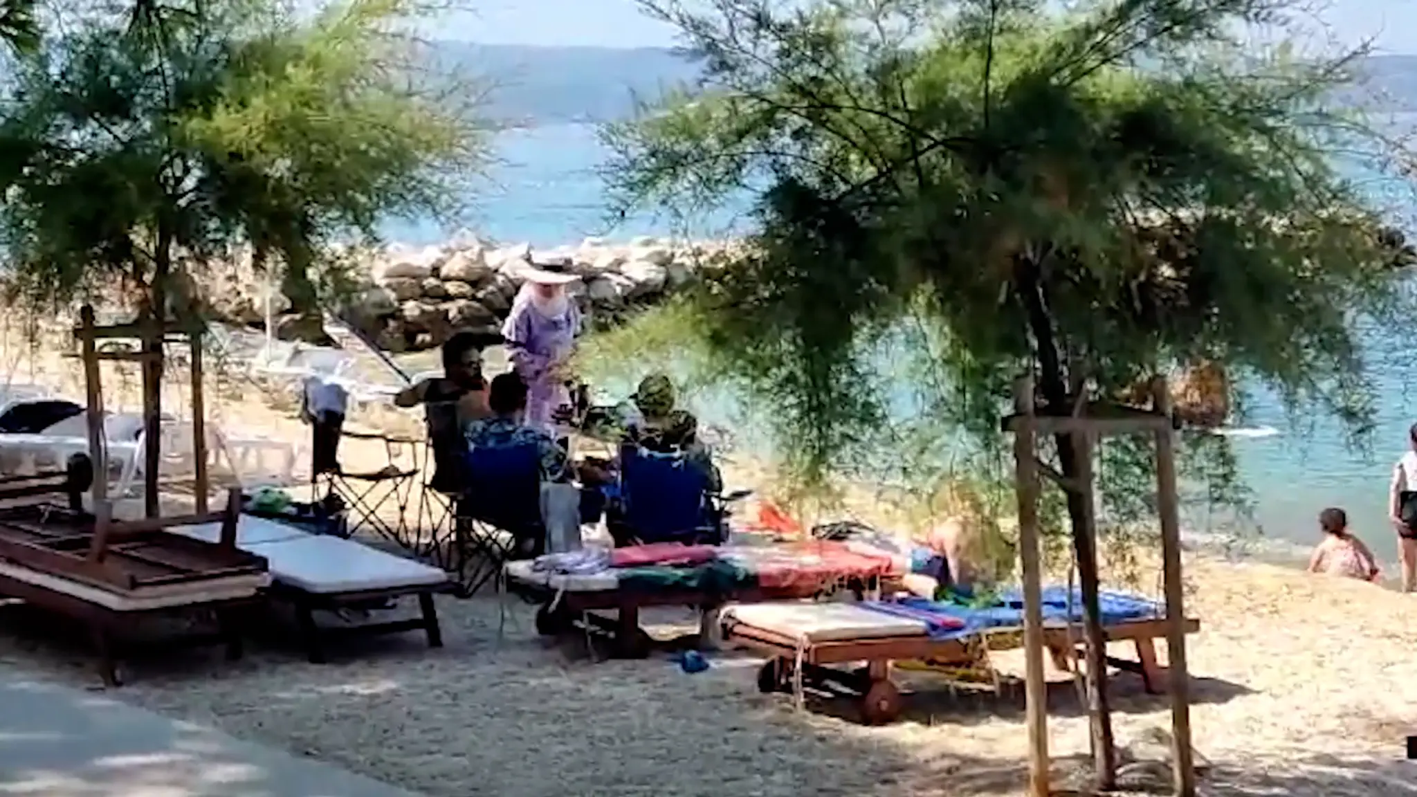 Skupina turistov si varí kávu priamo na pláži.