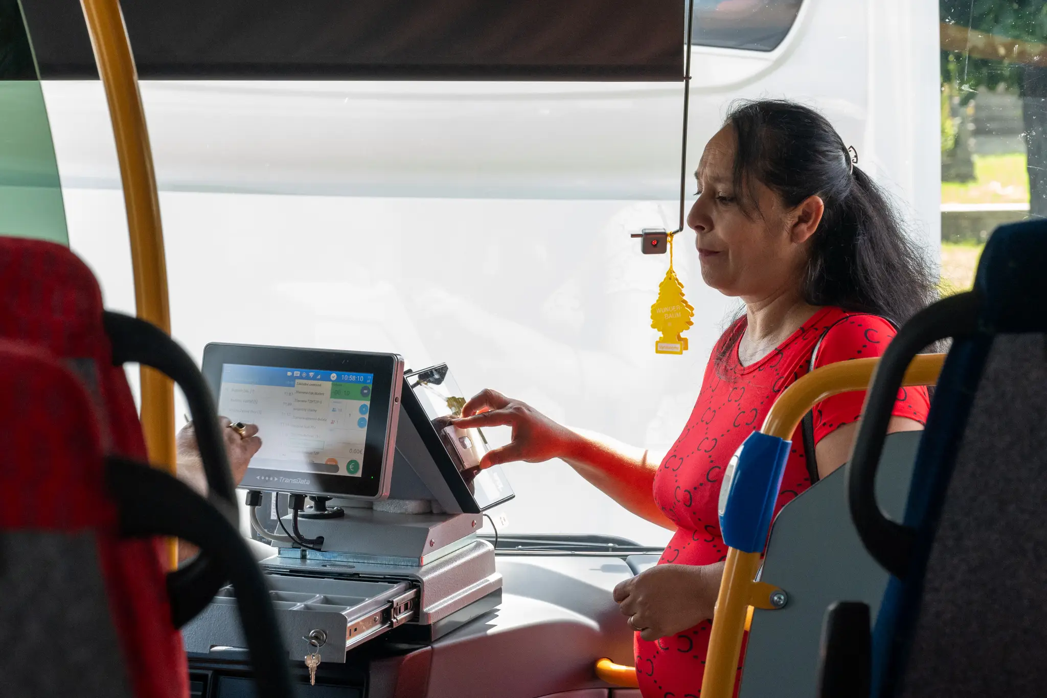 Na snímke cestujúca si kupuje lístok v autobuse.