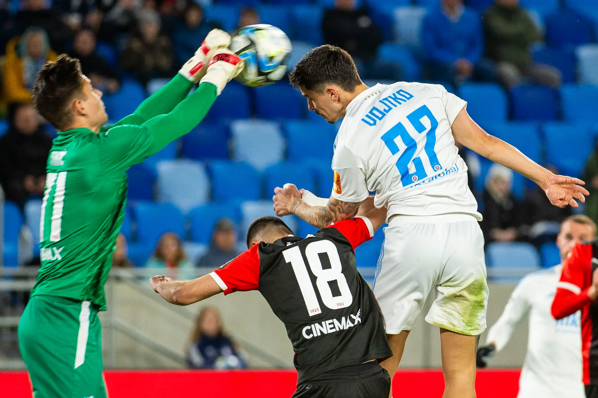 Matúš Vojtko sa snaží prehlavičkovať brankára Trnavy Dominika Takáča.