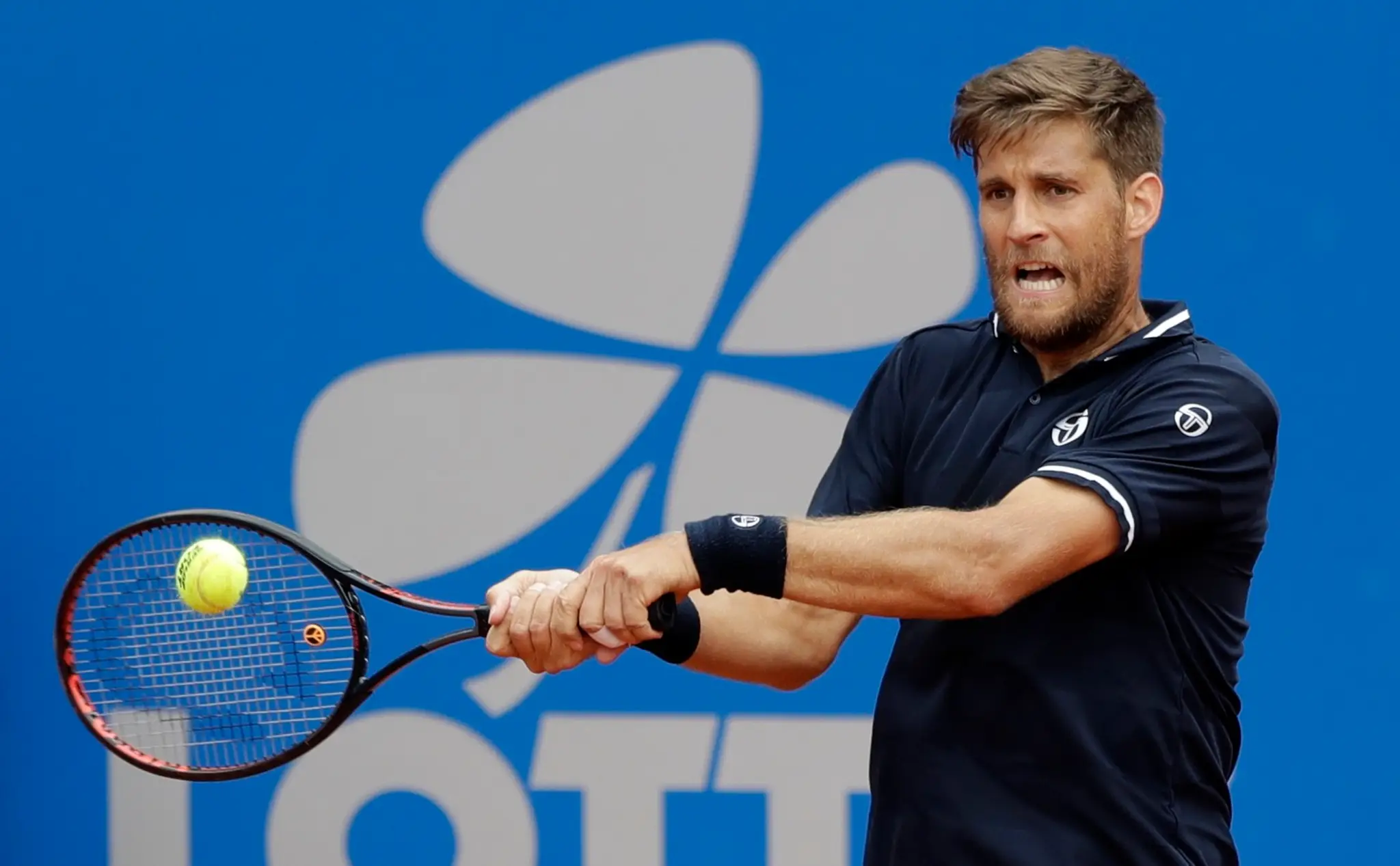 Martin Kližan odvracia úder Mirzu Bašiča z Bosny a Hercegoviny v zápase 2. kola na turnaji ATP v Mníchove.