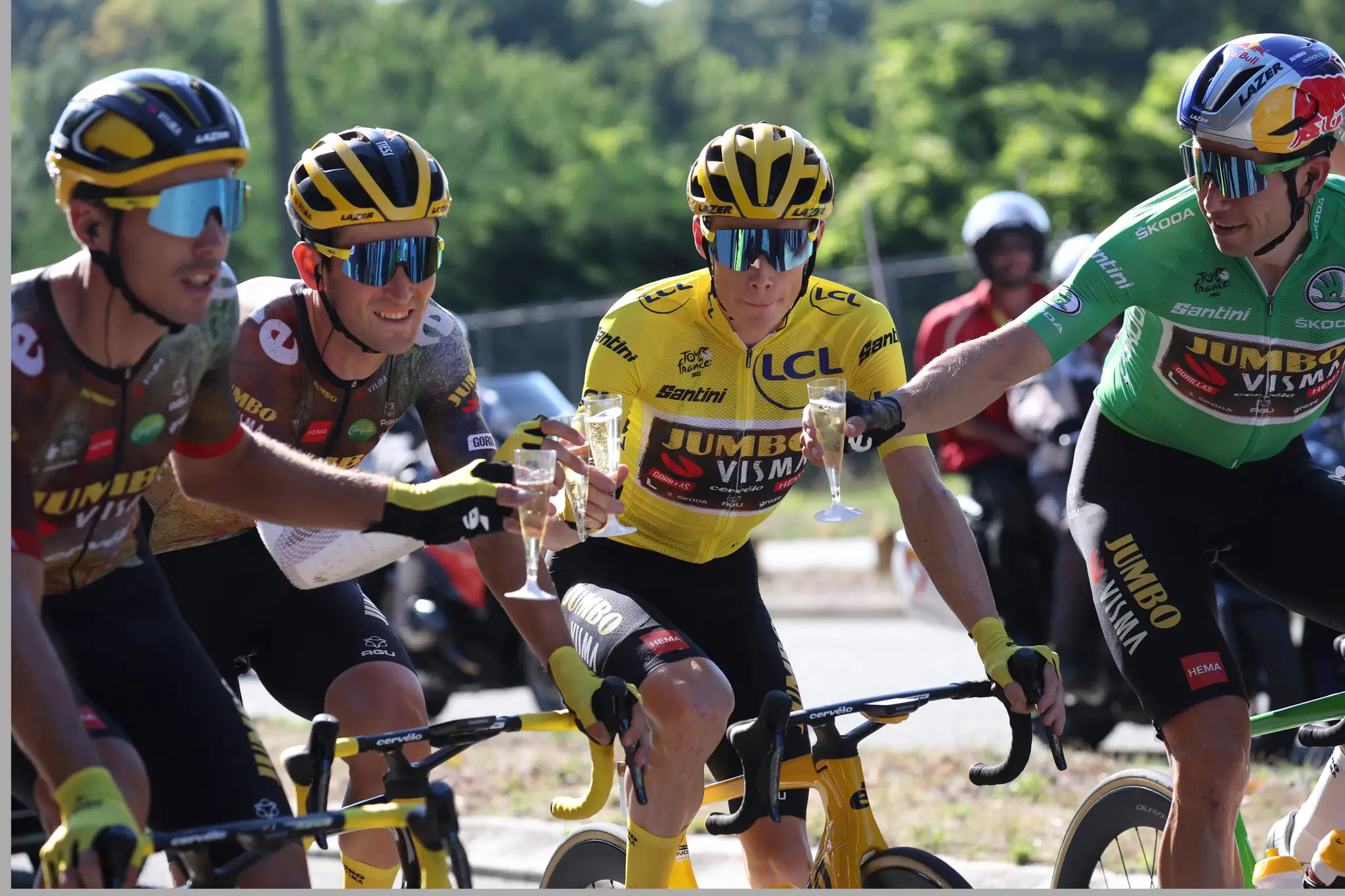 Jonas Vingegaard v žltom drese si pripíja šampanským s kolegami z tímu Jumbo-Visma, 