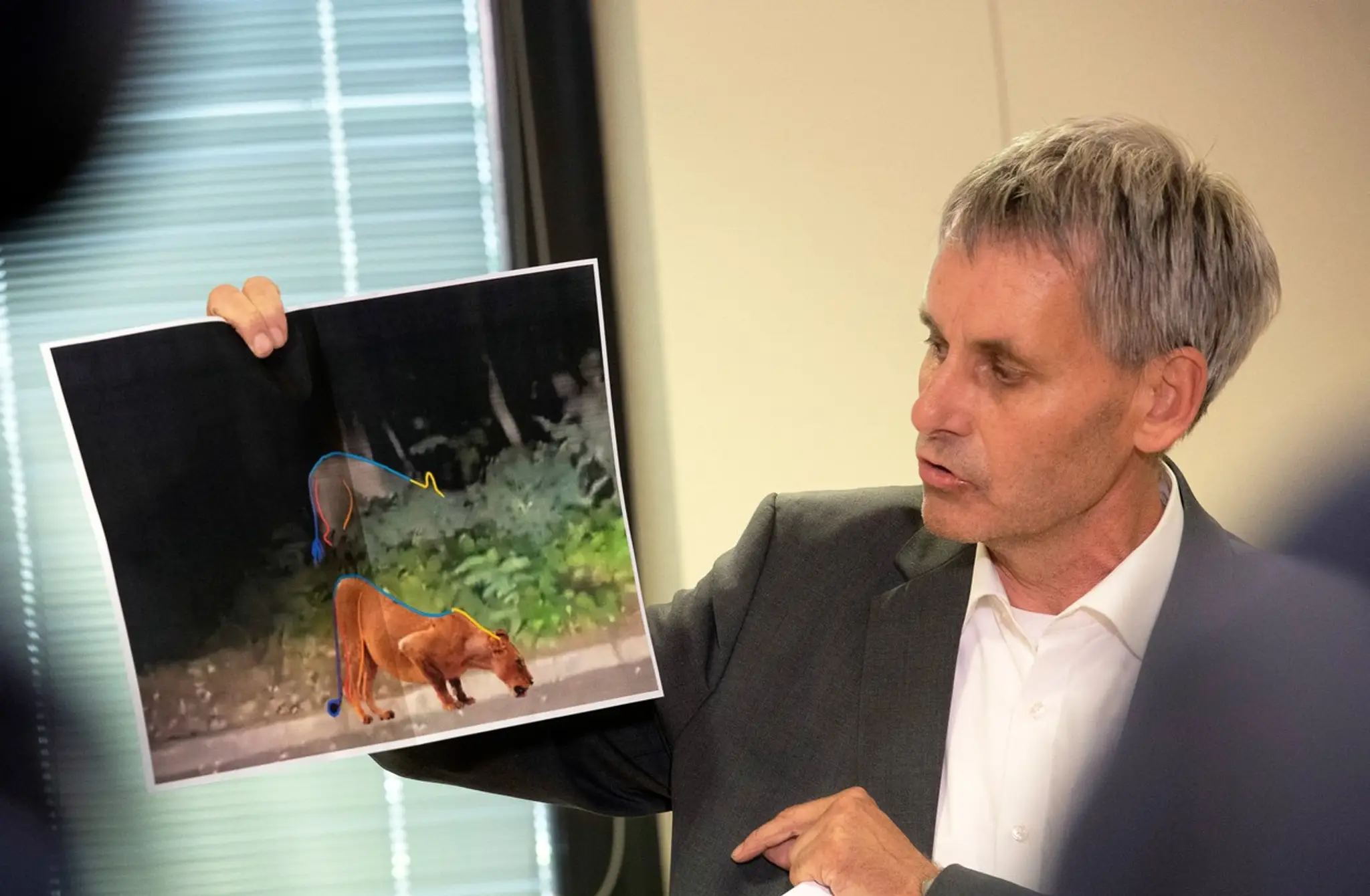 Starosta obce Kleinmachnow Michael Grubert na tlačovej konferencii ukazuje analýzu záberov z videa.