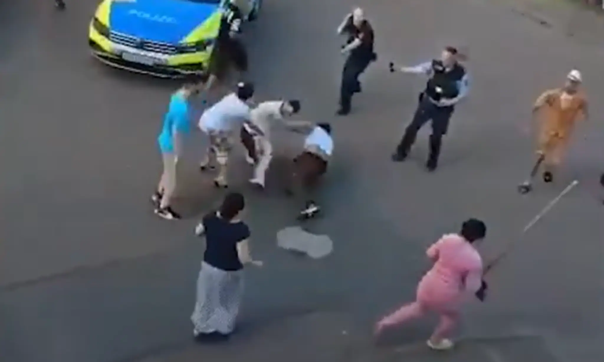 Policajti sa prizerajú na bitku klanov.