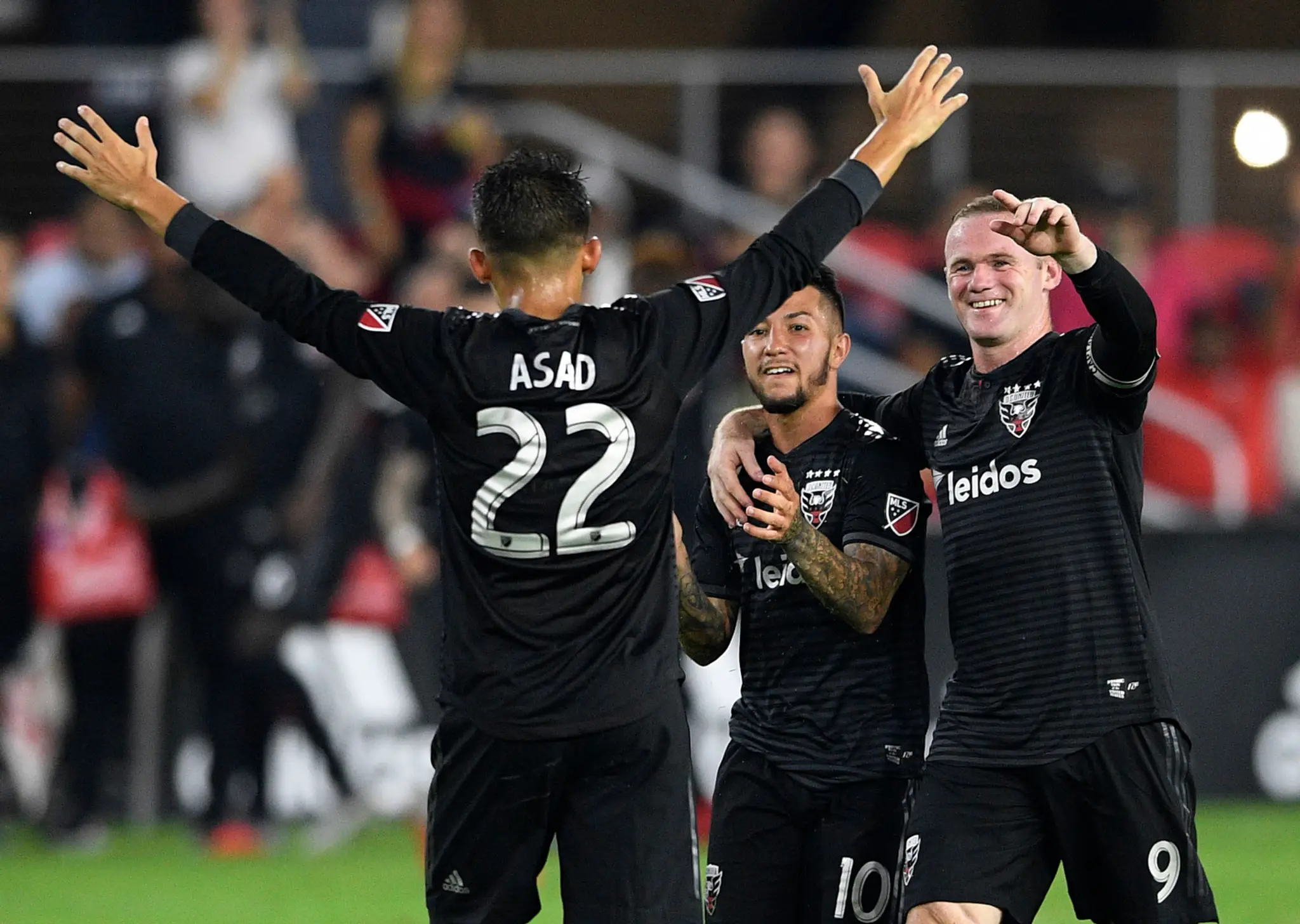 Hráči D.C. United, Luciano Acosta (v strede) Wayne Rooney (vpravo) a Yamil Asad oslavujú gól proti Orlandu.