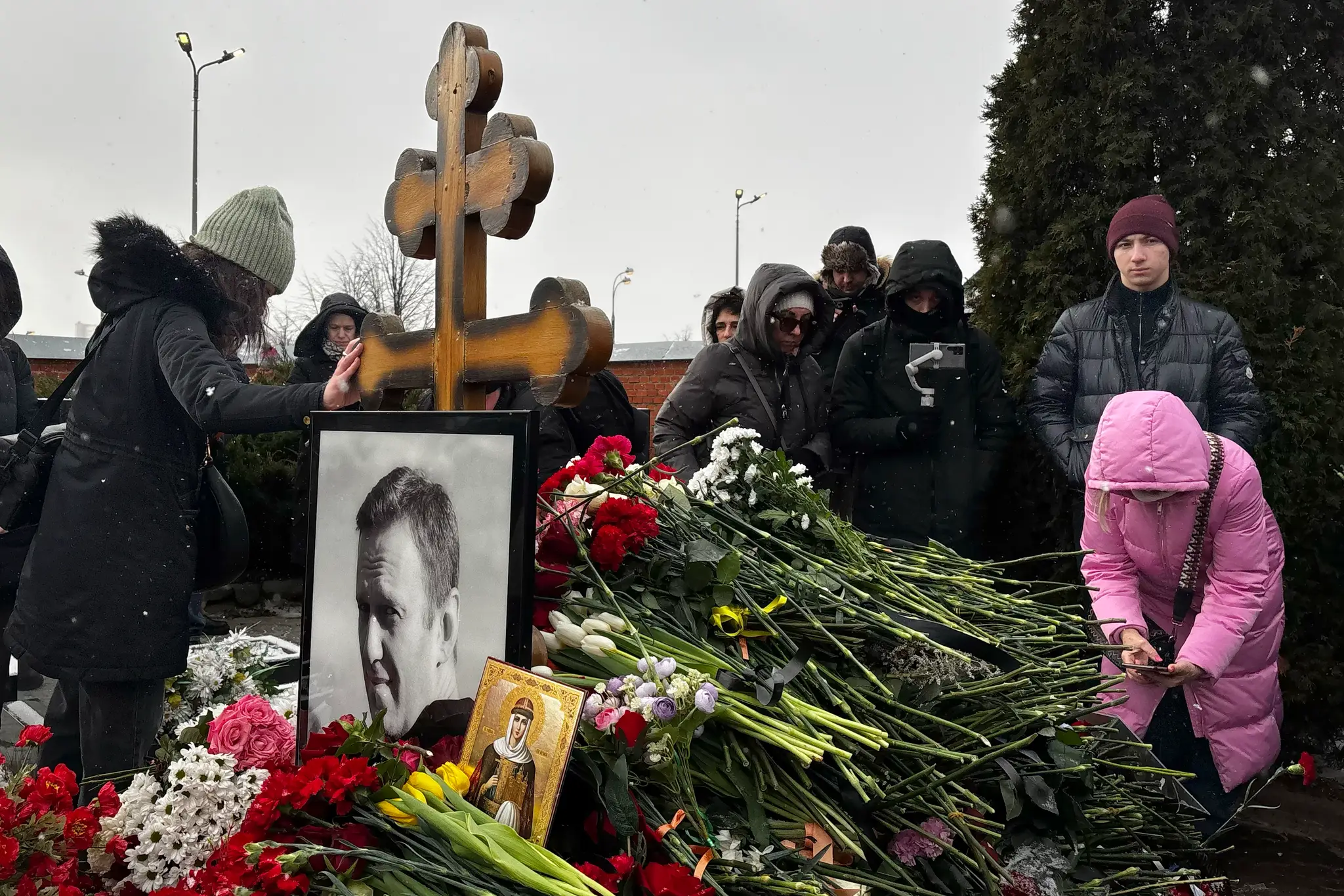 Ľudia kladú kvety na hrob ruského opozičného politika Alexeja Navaľného pri príležitosti prvého výročia jeho smrti na Borisovskom cintoríne v  Moskve.