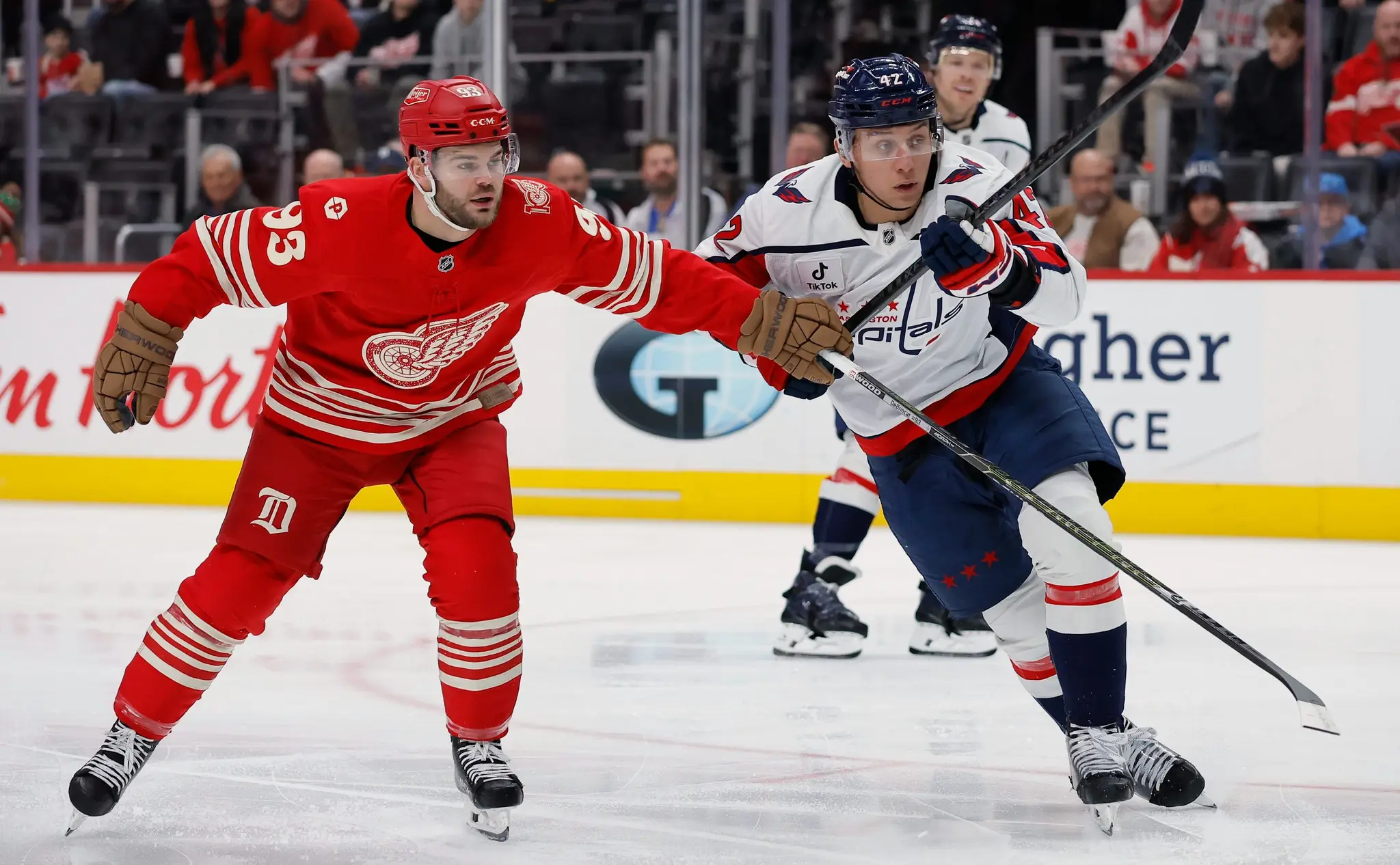 Alex DeBrincat a Martin Fehérváry v súboji o puk.