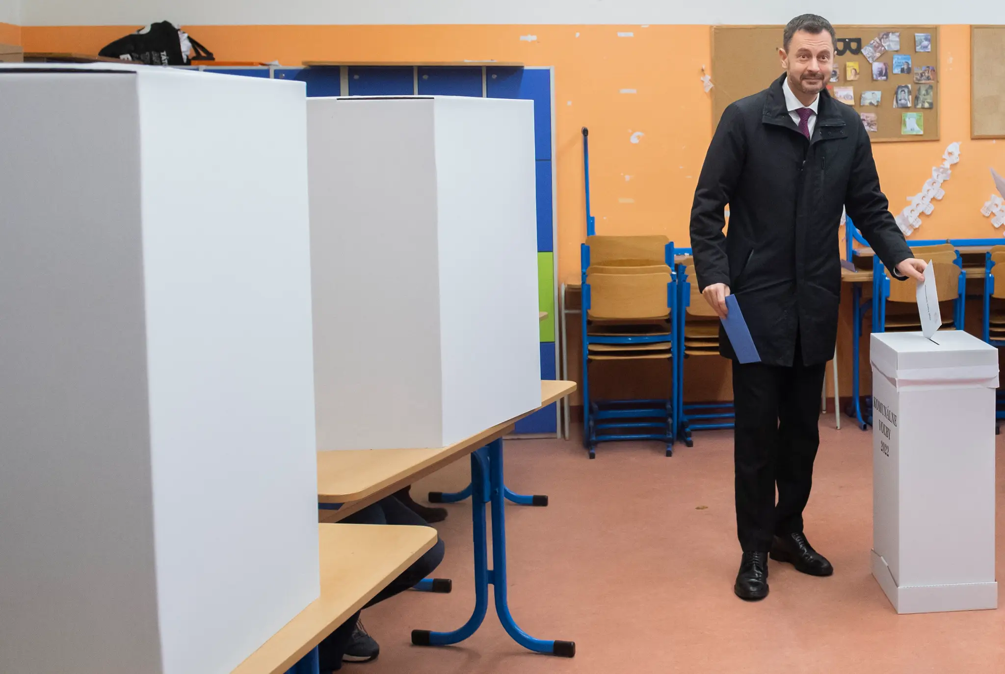 Premiér Eduard Heger vhadzuje obálku s hlasovacími lístkami do volebnej schránky pre komunálne voľby.