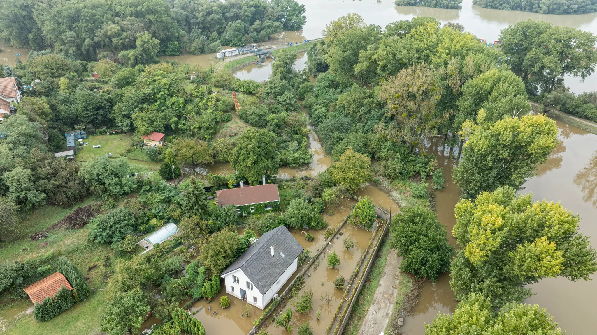Na snímke z dronu zaplavené pozemky a domy  riekou Morava pri Devínskej Novej Vsi.