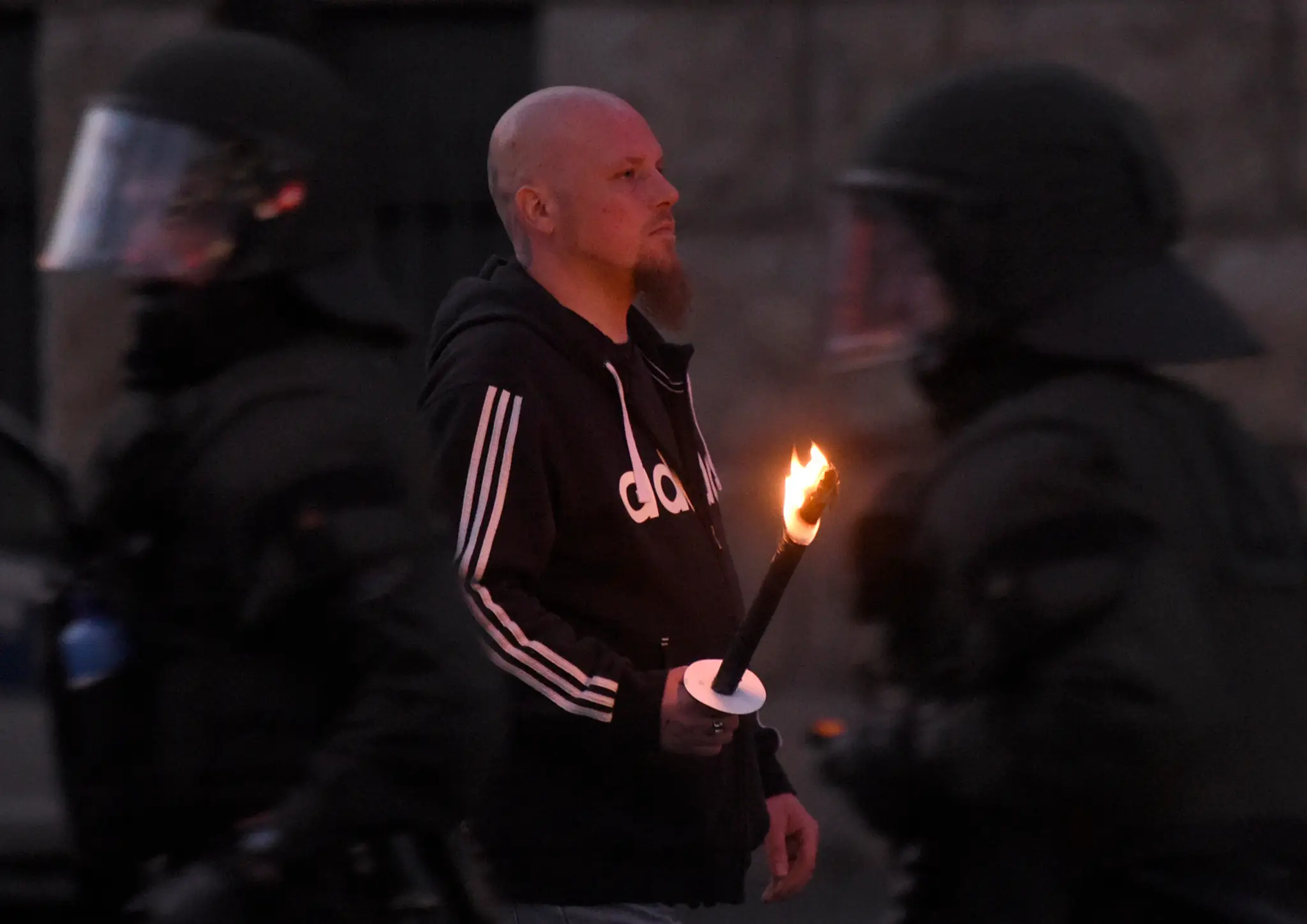 Krajne pravicový demonštrant drží pochodeň.