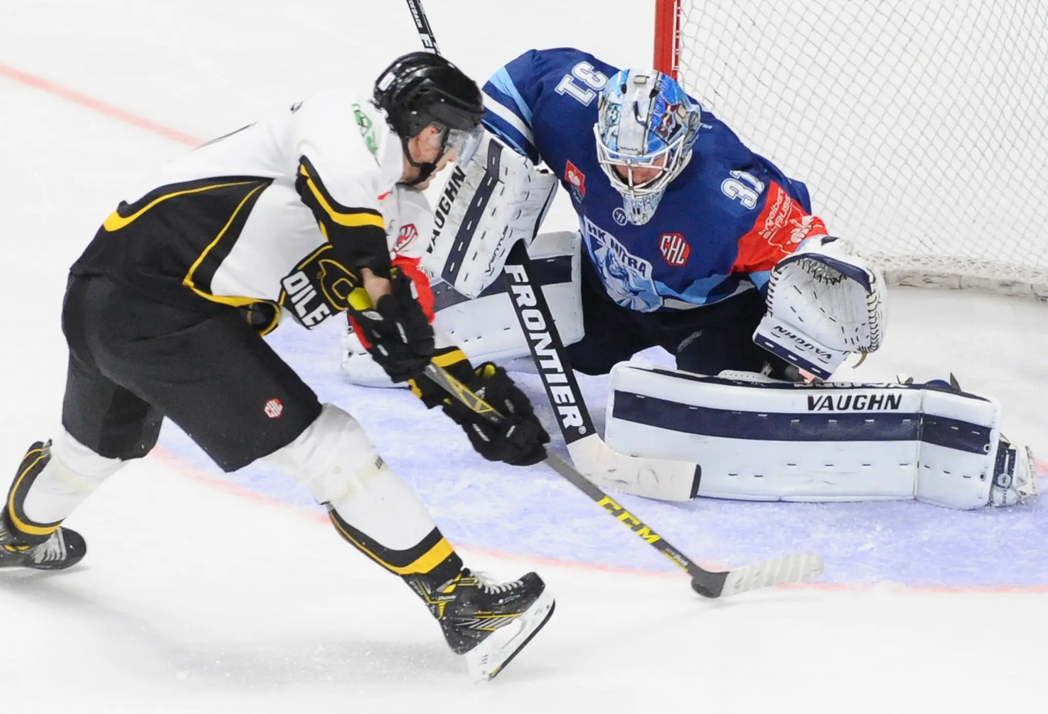 Christian Andersen zo Stavanger (vľavo) a brankár Nitry Michal Valent v zápase J-skupiny hokejovej Ligy majstrov.