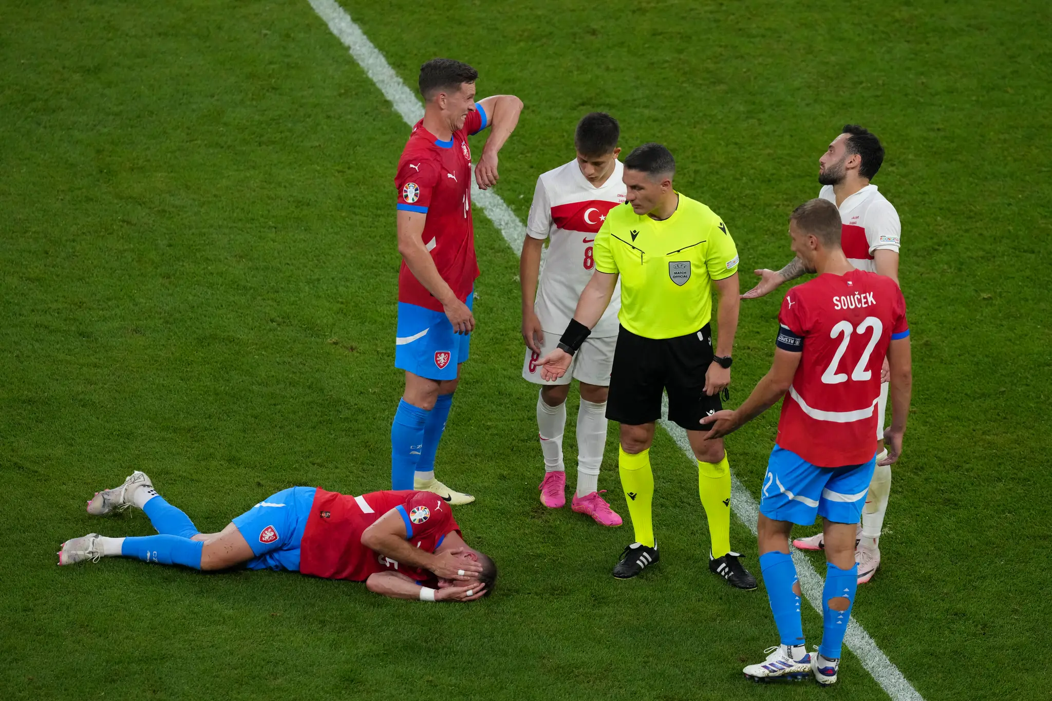 Český futbalista Vladimír Coufal leží zranený na zemi počas  zápasu.