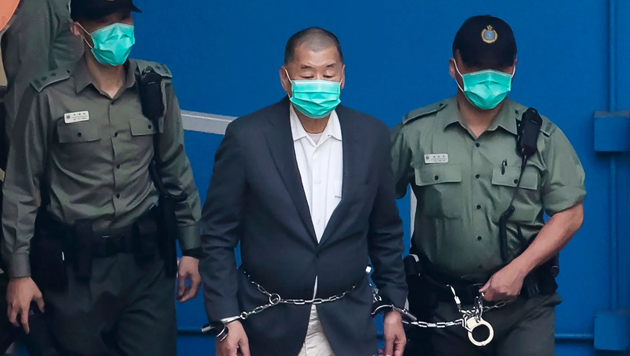 Jimmyho Laia privádzajú policajti v putách na súd v Hongkongu.