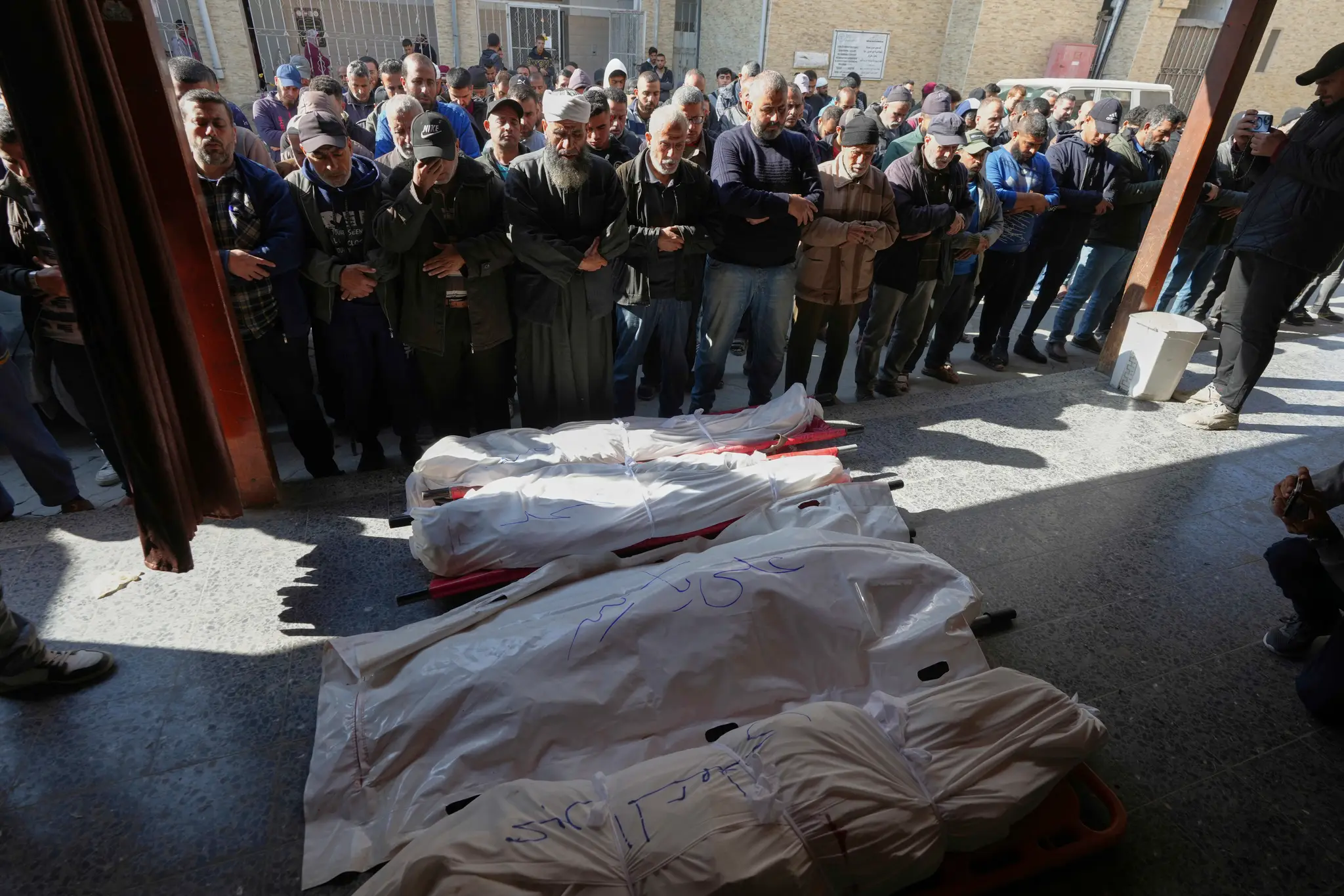 Smútiaci sa modlia nad telami štyroch Palestínčanov, ktorí zahynuli pri izraelskom leteckom útoku v koridore Netzarim v nemocnici Al-Ahli v meste Gaza.