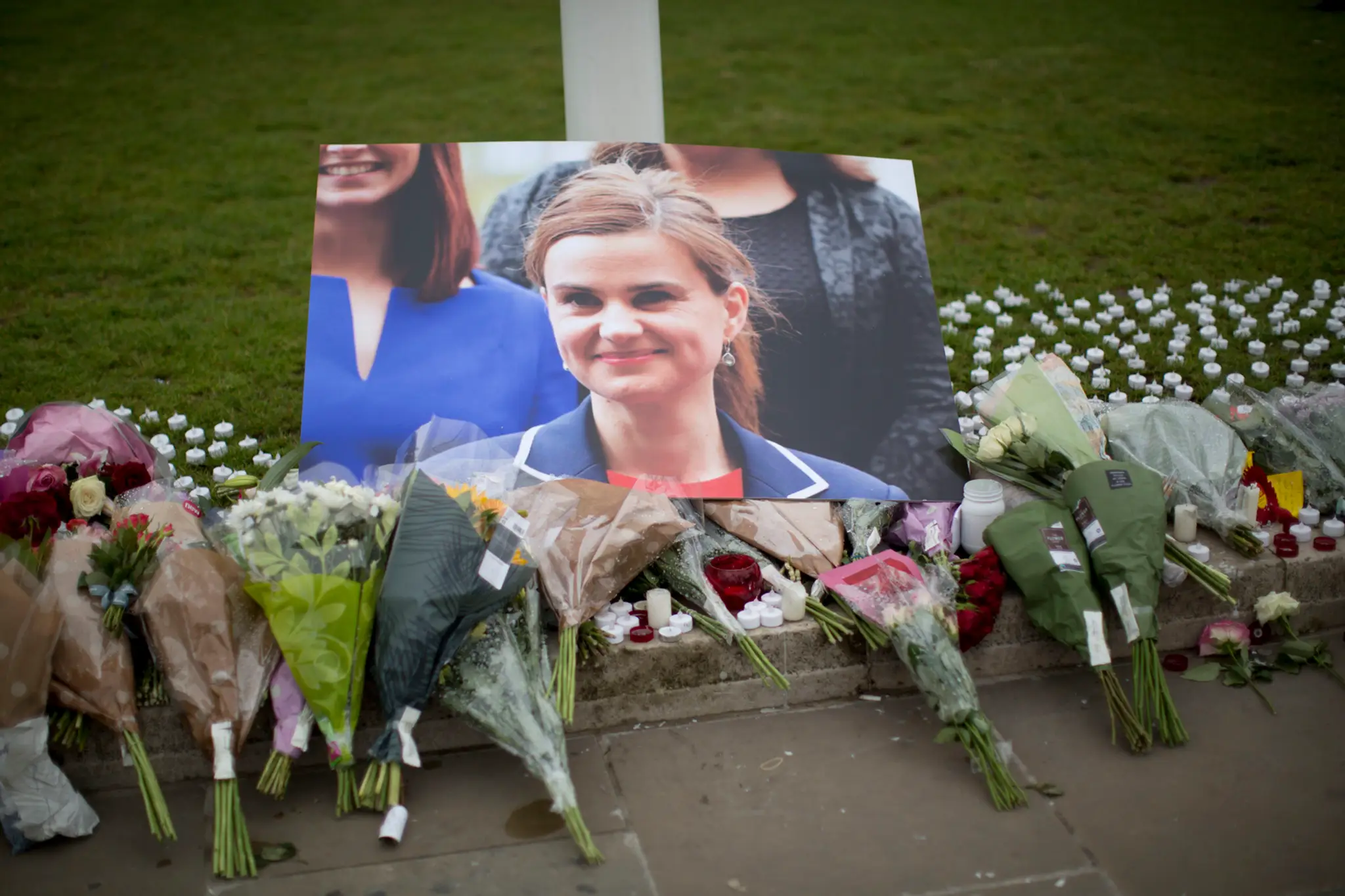 Kvety na znak úcty pri obrázku zabitej britskej labouristickej poslankyne Jo Coxovej neďaleko parlamentu v Londýne..