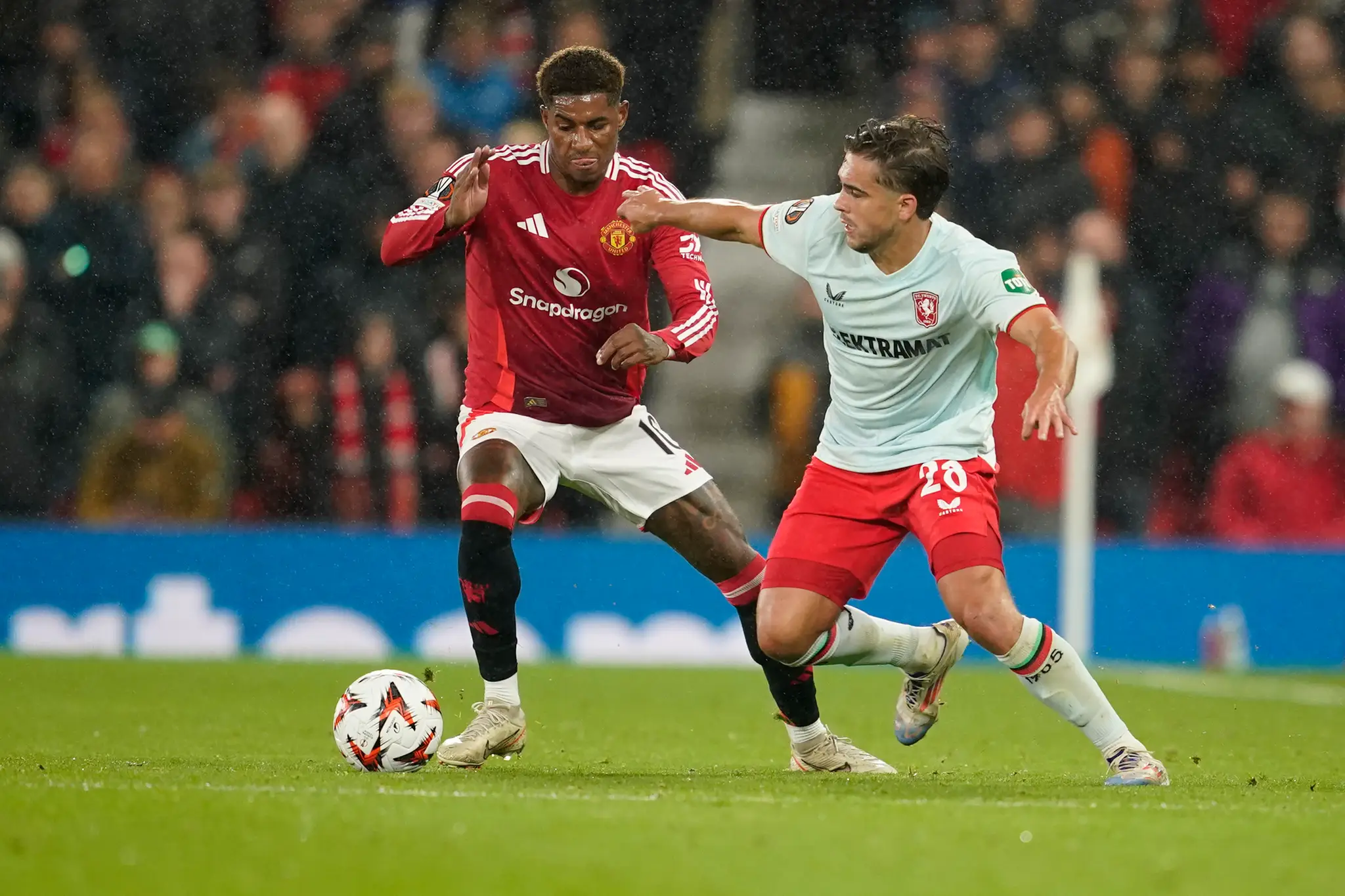 Hráč Manchesteru United Marcus Rashford (vľavo) bojuje o loptu s Bartom van Roojom z Twente