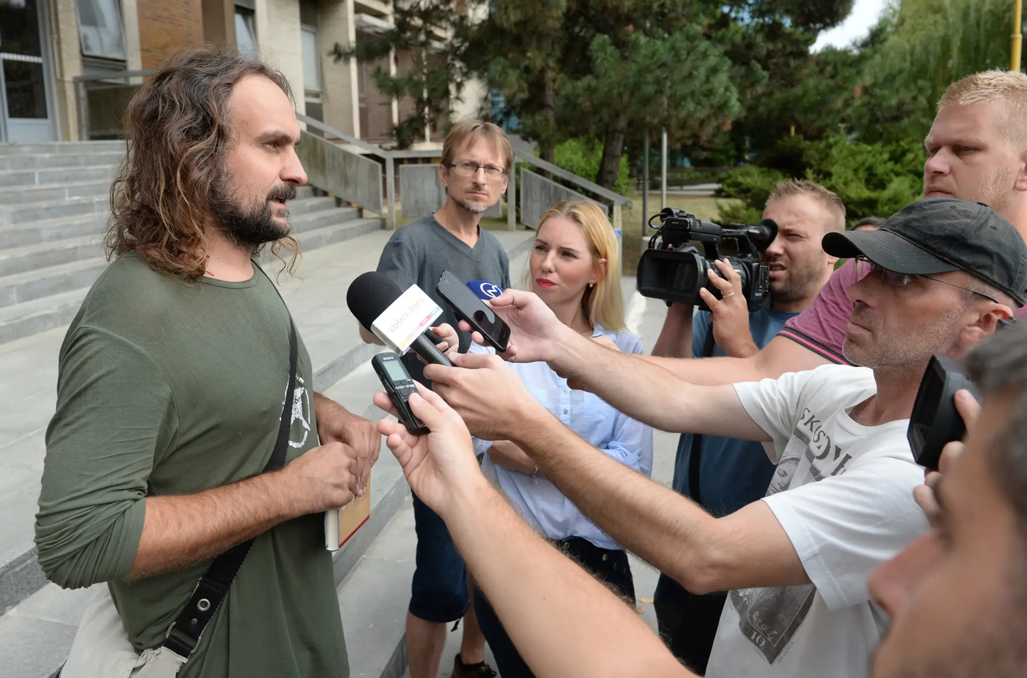 Ľuboš Lorenz pred budovou súdu po prepustení z policajného zadržania medzi novinármi.