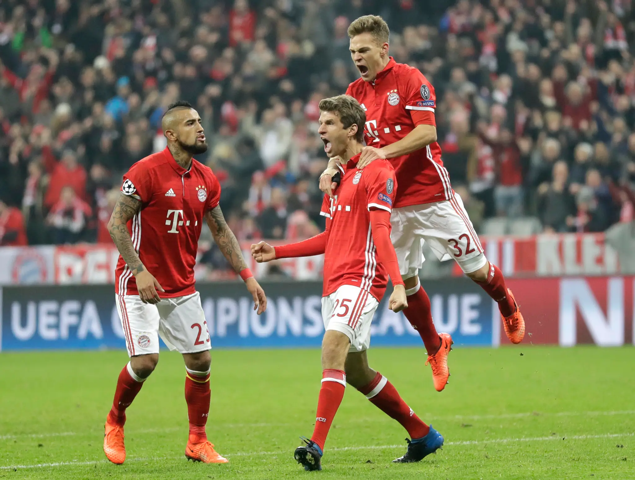 Thomas Müller (v strede) z Bayernu jasá po svojom góle v osemfinále LM proti Arsenalu, vľavo Arturo Vidal a vpravo Joshua Kimmic