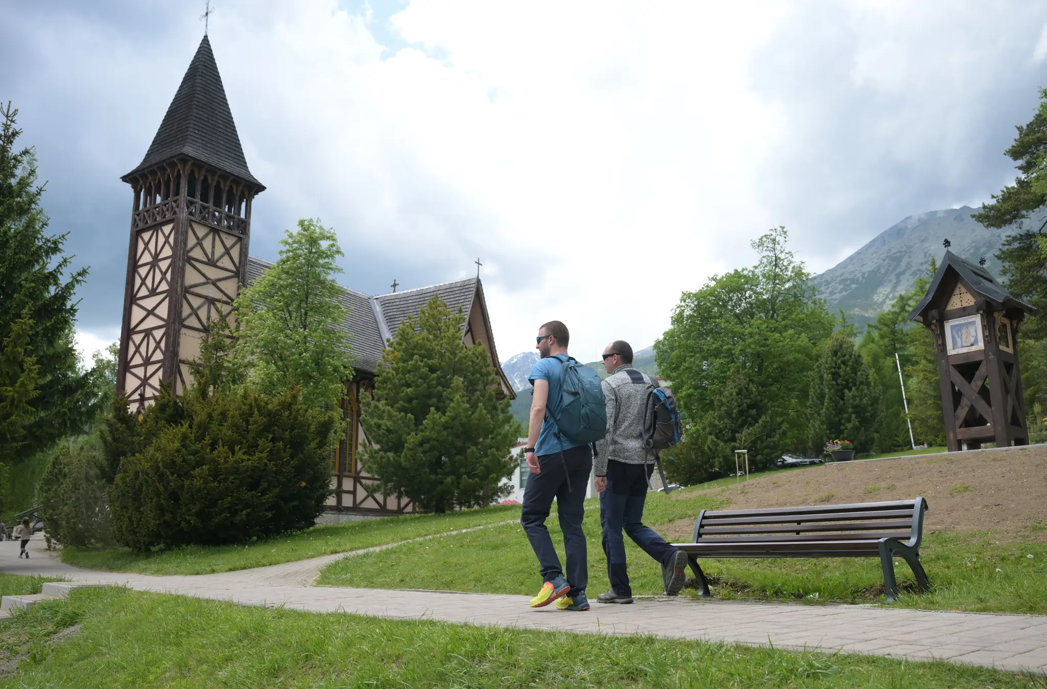 Turisti kráčajú pri Kostole Nepoškvrneného počatia Panny Márie v Starom Smokovci 