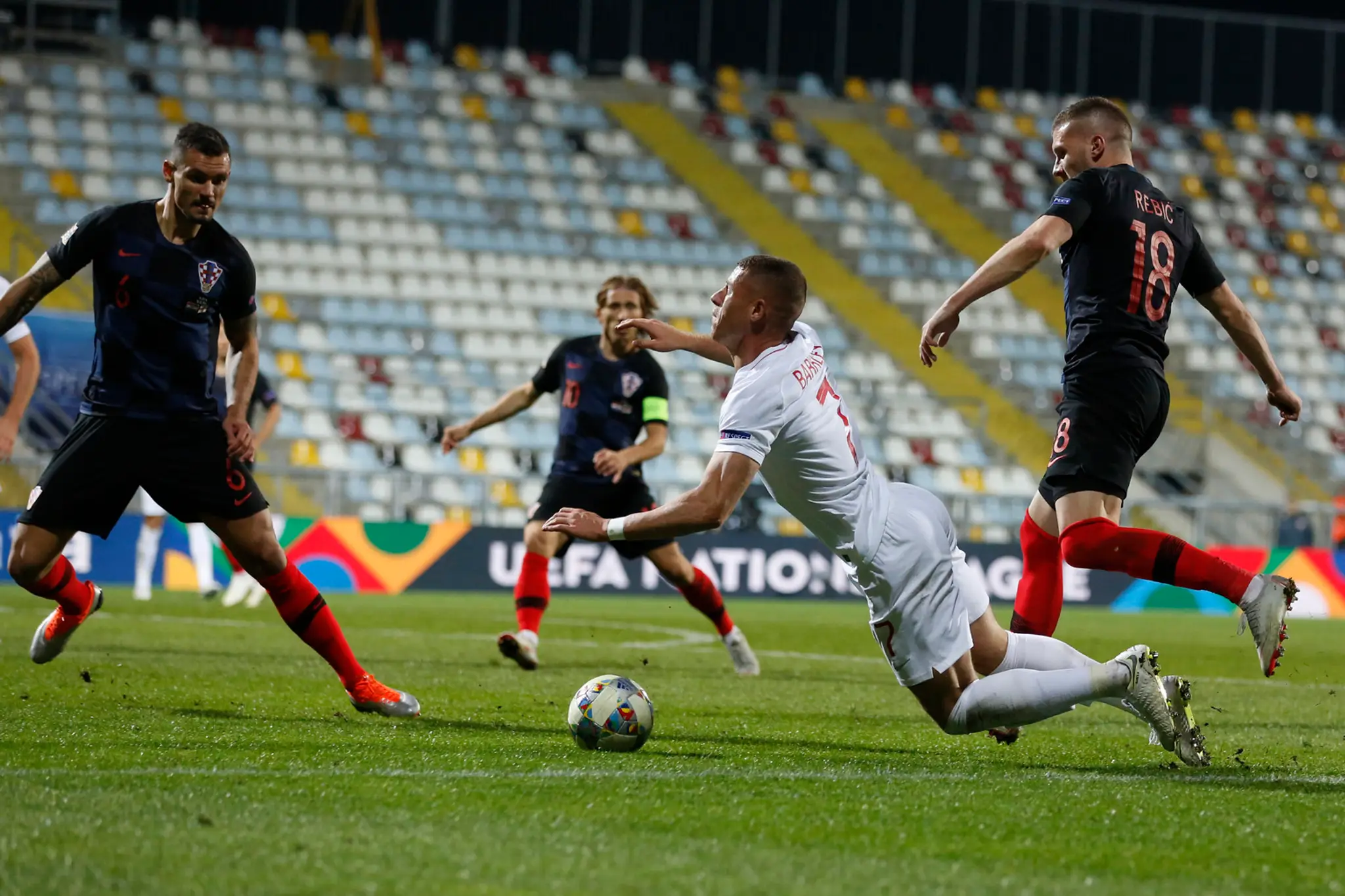 Hráč Anglicka Ross Barkley (v strede) padá v súboji s Chorvátom Markom Rogom.