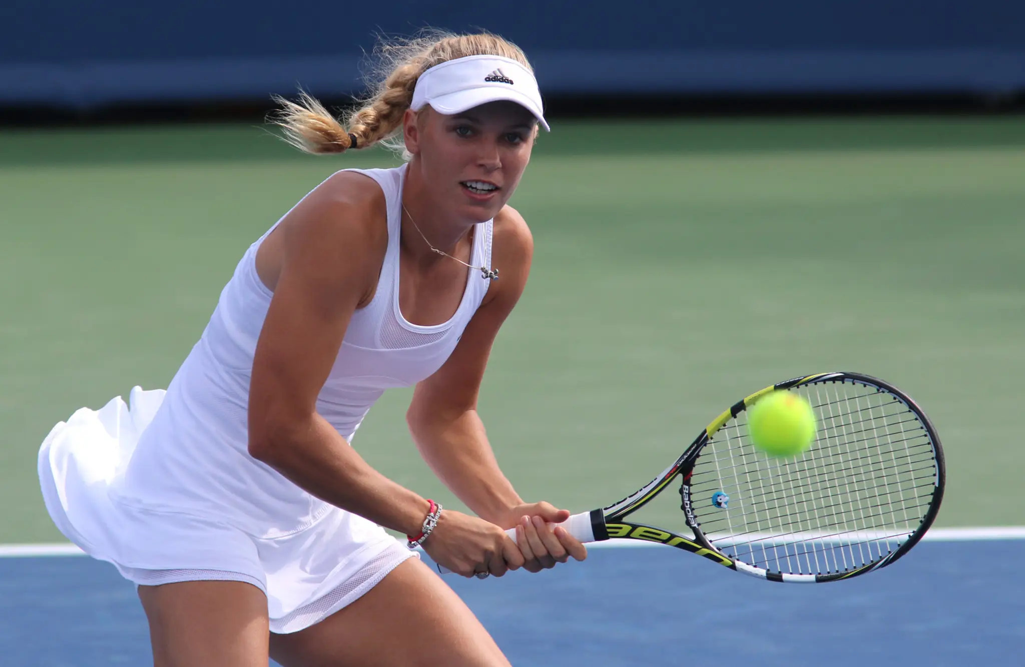 Dánska tenistka Caroline Wozniacka  odvracia loptičku Slovenke Magdaléne Rybárikovej v 1. kole turnaja v Cincinnati.