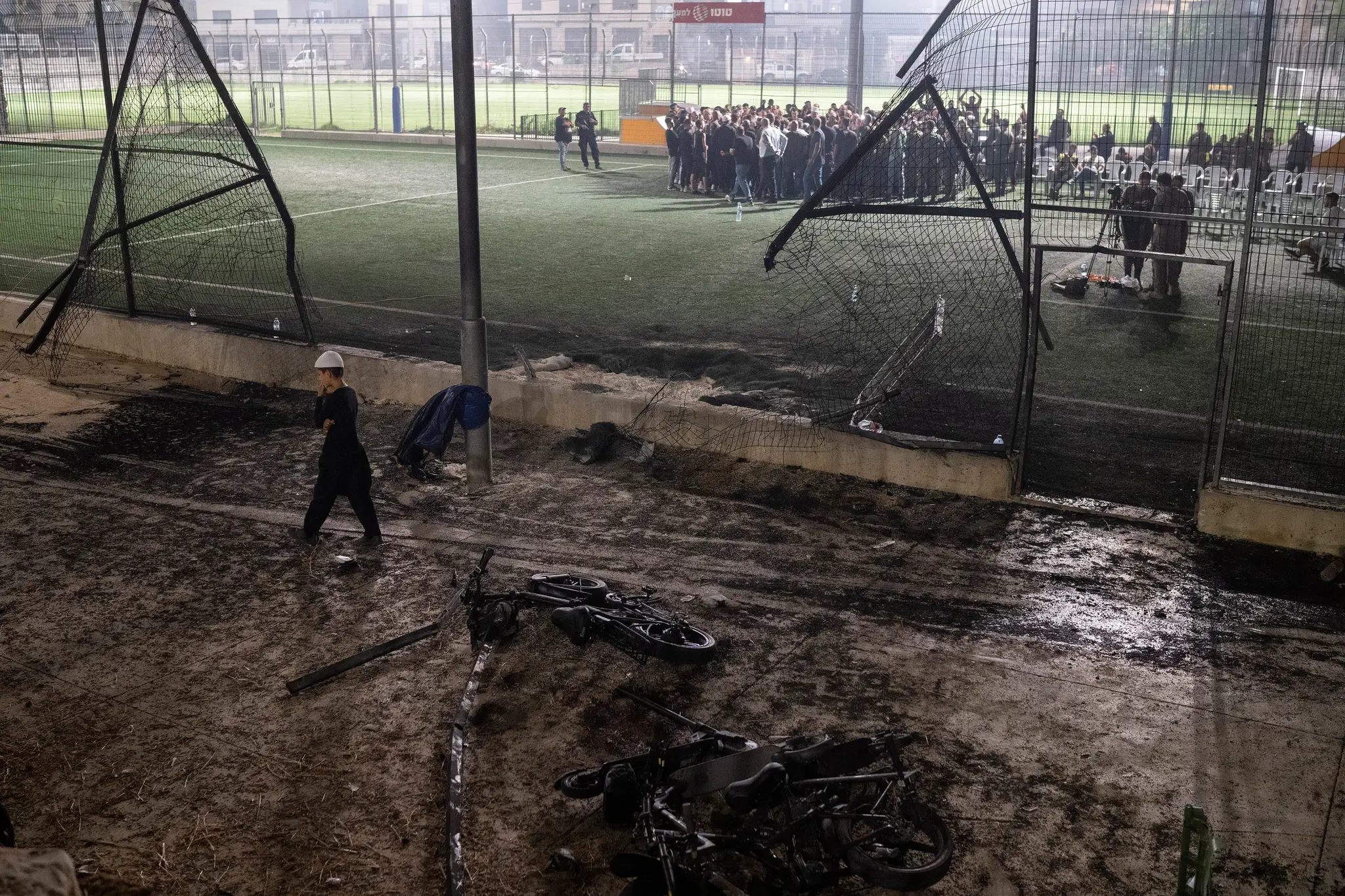 Chlapec kráča okolo bicyklov položených neďaleko futbalového ihriska, ktoré zasiahla raketa v meste Madždal Šams.