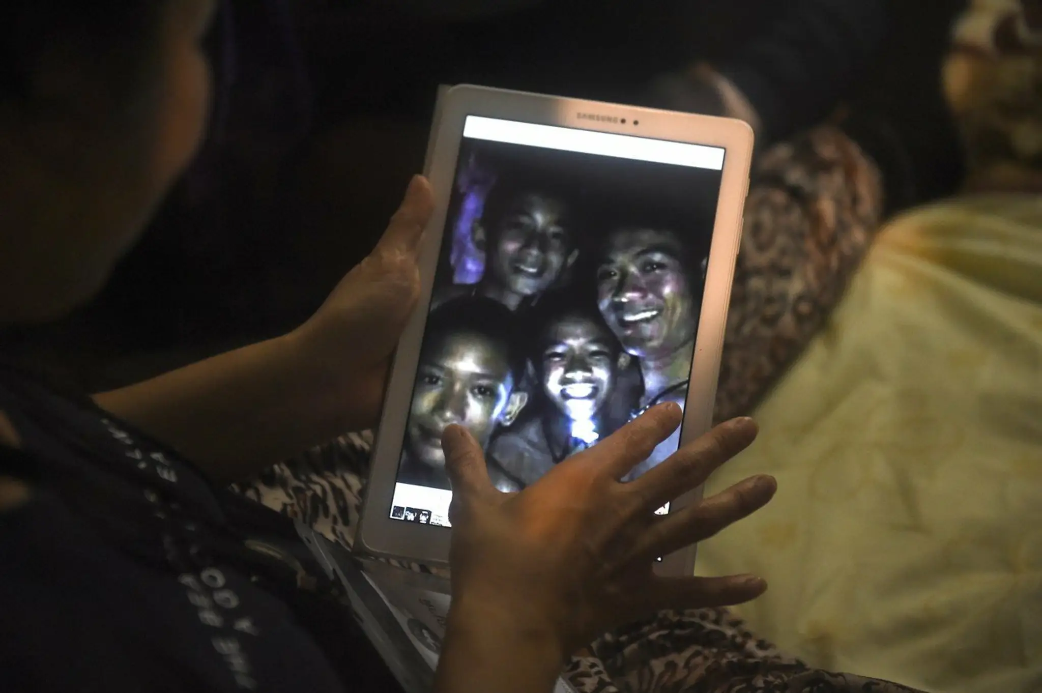 Mama jedného z chlapcov drží tablet s fotografiou, ktorú urobili potápači.