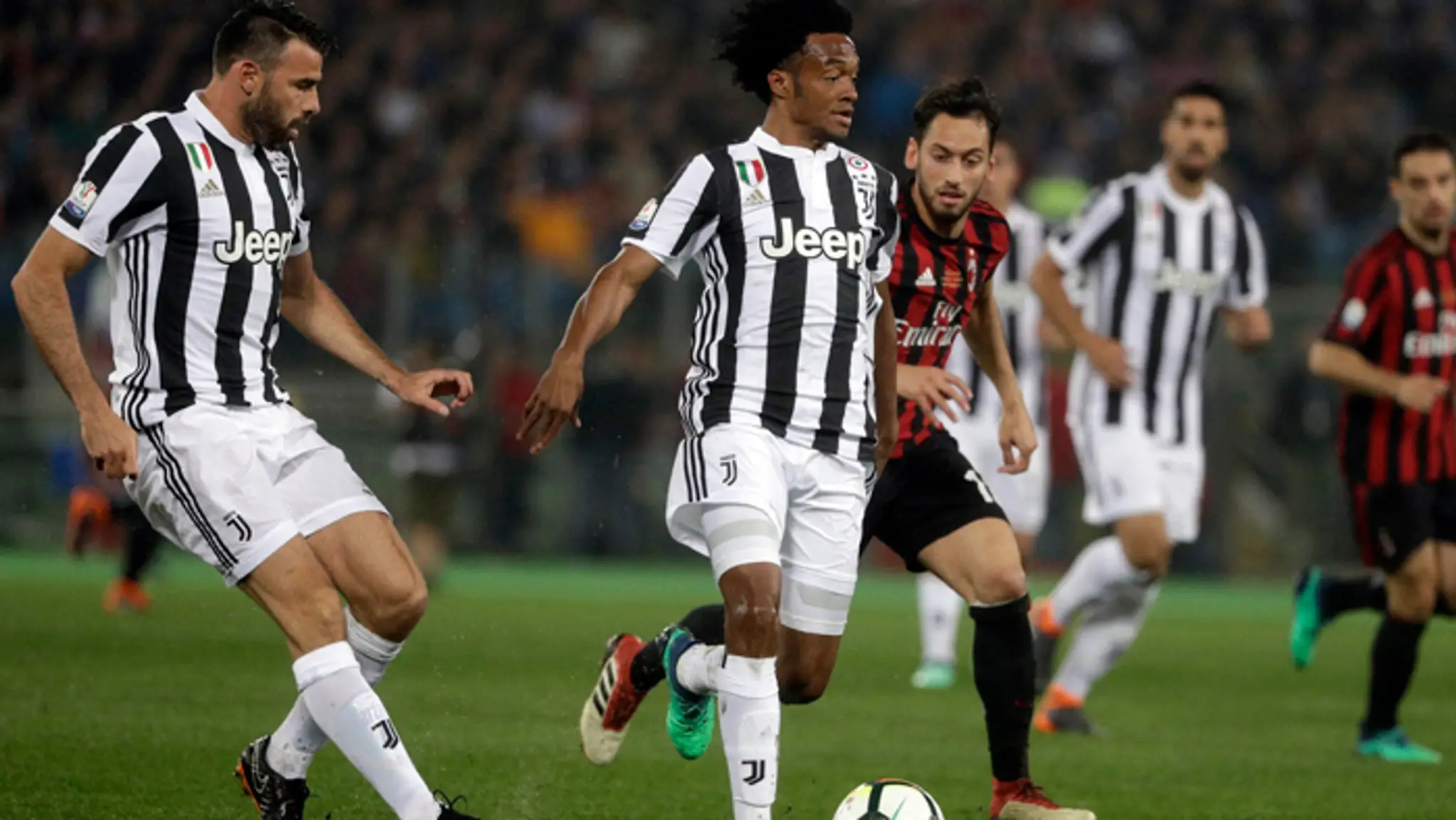 Druhý zľava hráč Juventusu Juan Cuadrado, naľavo hráč Milána Andrea Barzagli vo finále Talianskeho pohára.