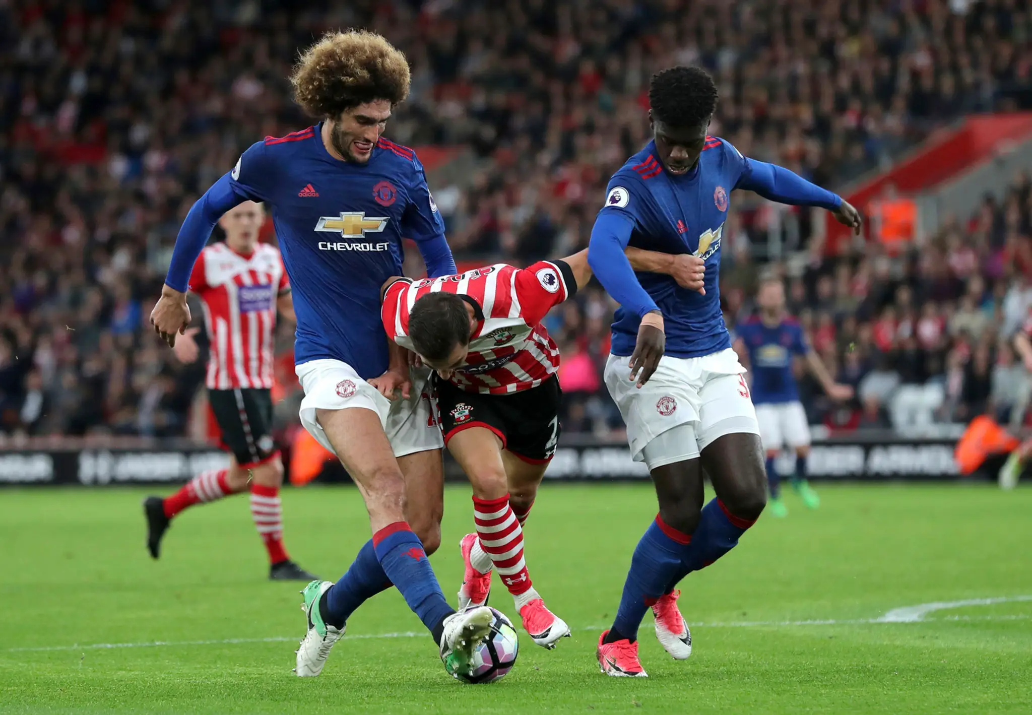 Cédrica Soaresa (v strede) zo Southamptonu atakuje v dueli PL dvojica z ManUtd Marouane Fellaini (vľavo) a Eric Bailly.