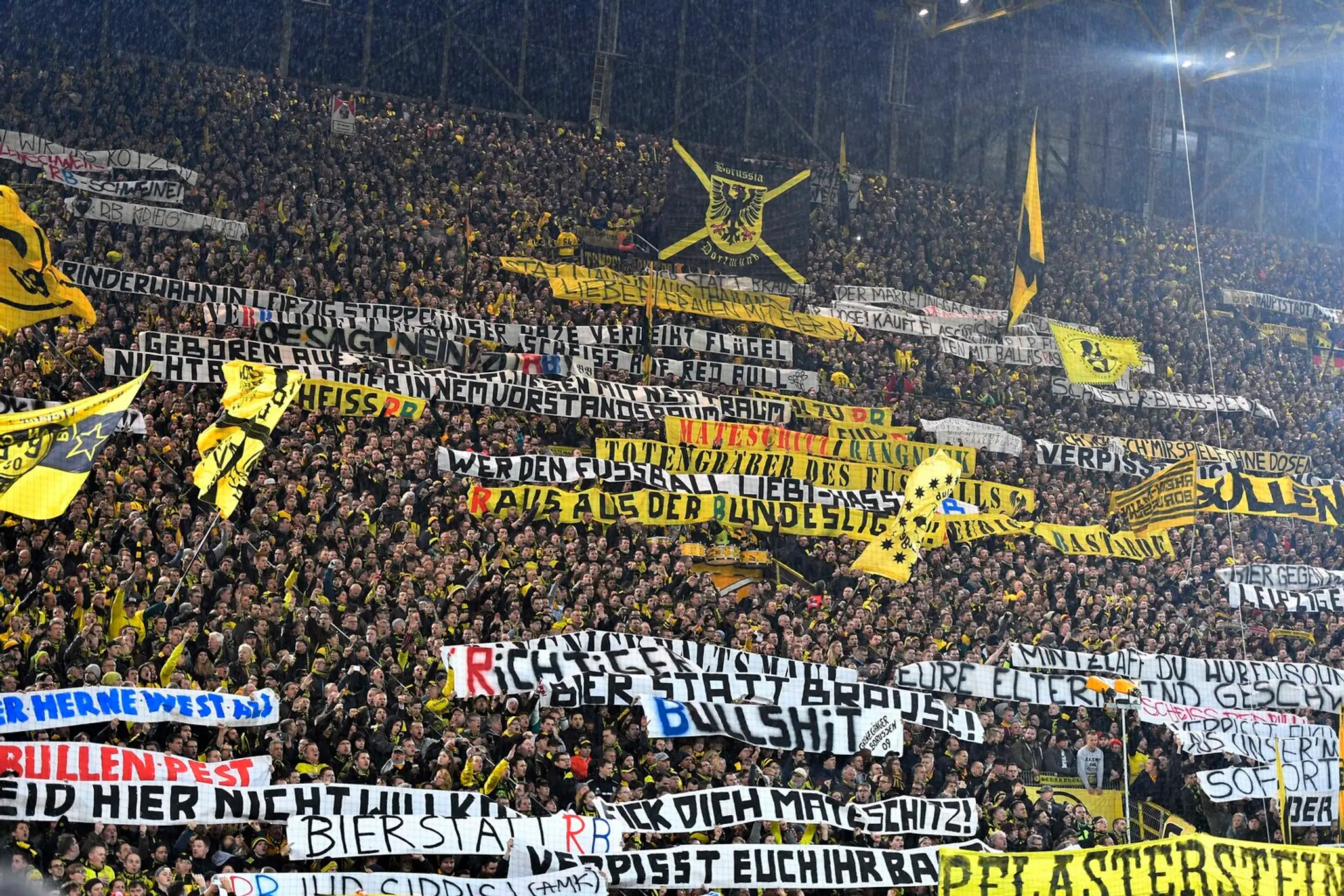Priaznivci Borussie Dortmund s transparentmi proti tímu RB Lipsko.