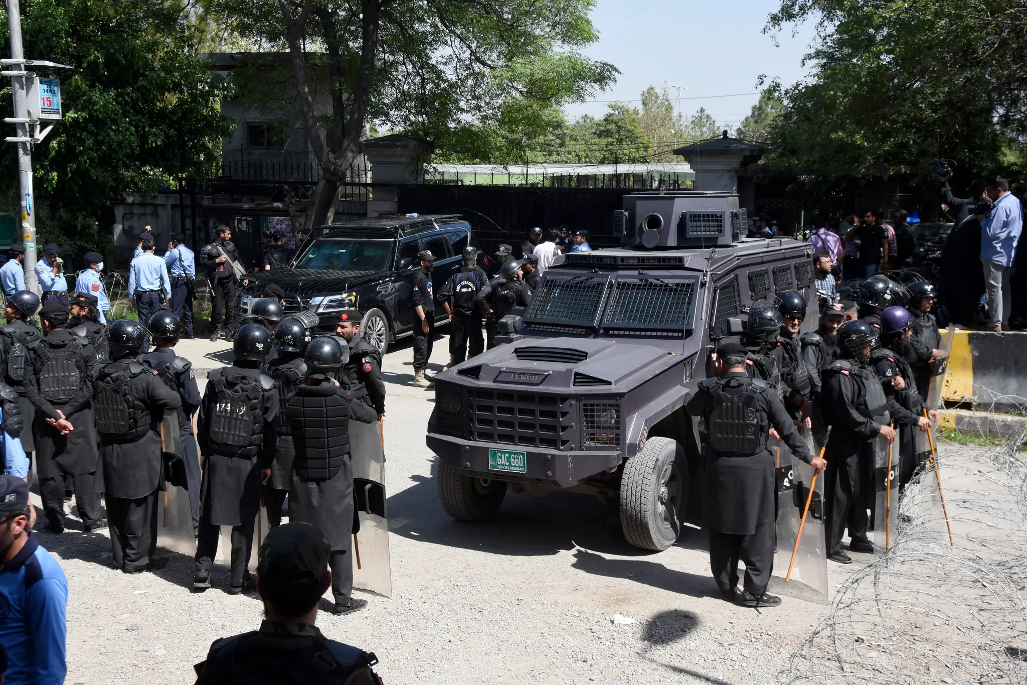 Pakistanskí policajti stoja pred súdom, kde zadržali bývalého pakistanského premiéra Imrana Chána.