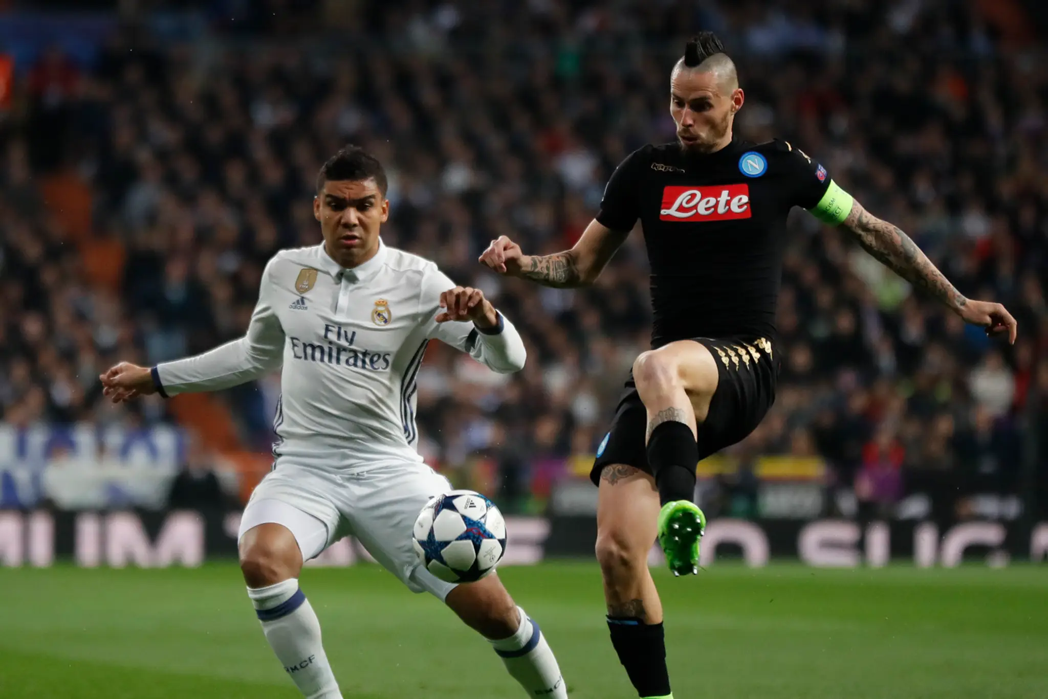 Kapitán Neapola Marek Hamšík (vpravo) bojuje o loptu s Casemirom z Realu v osemfinále LM.