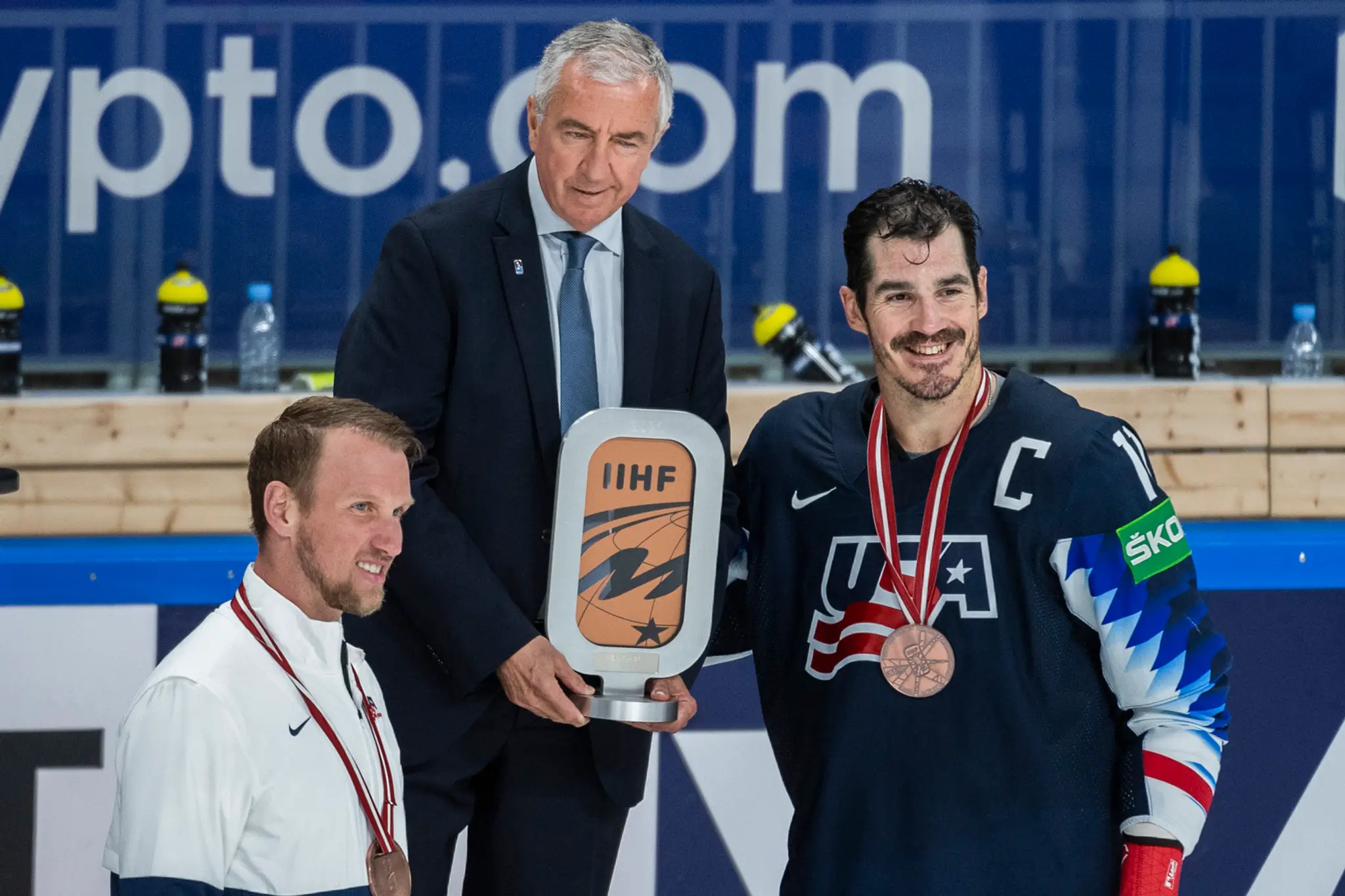 Prezident IIHF Luc Tardif odovzdáva ocenenie hráčom USA.