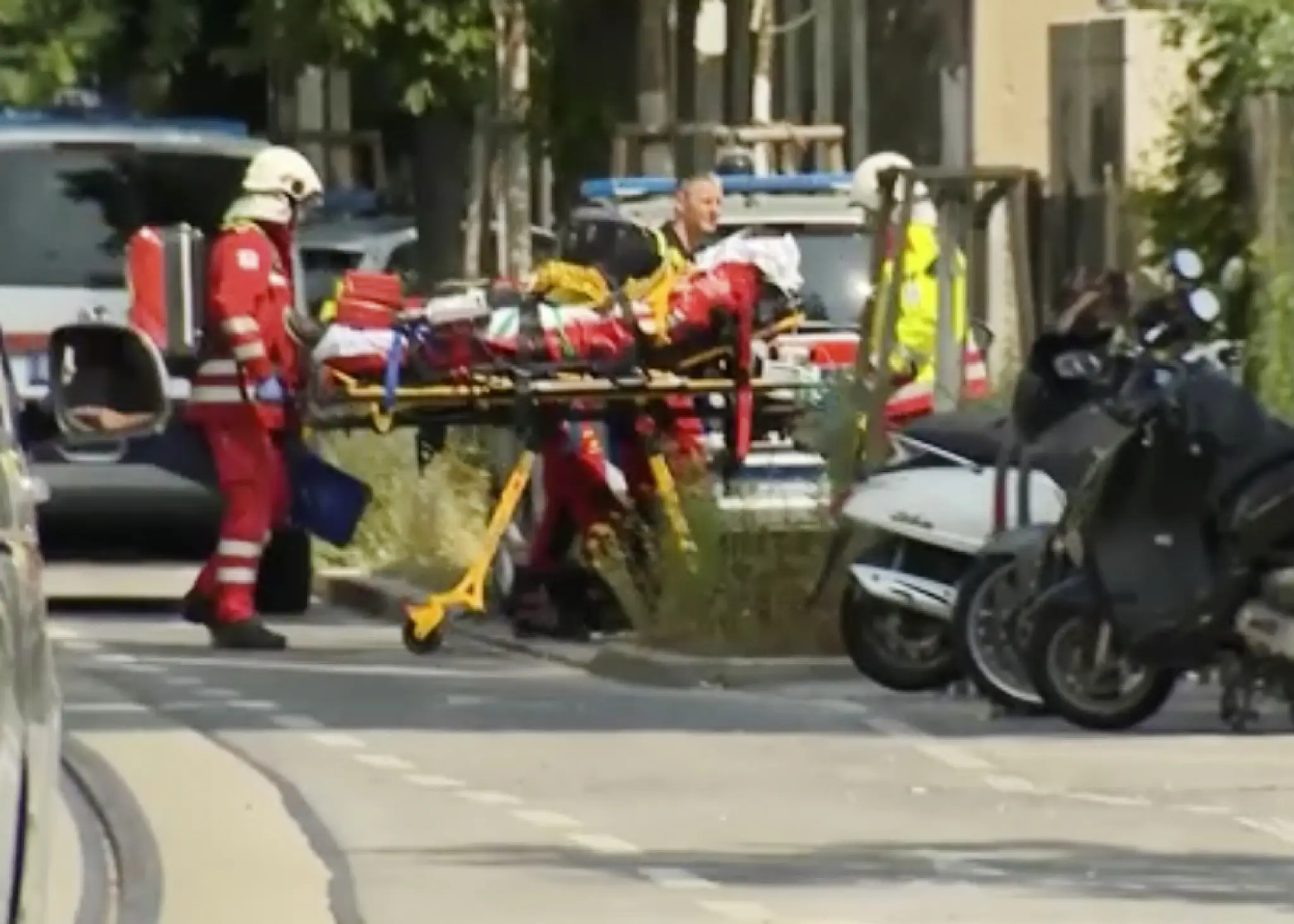 Na snímke z televízie policajti a záchranári na mieste streľby na strednej škole v rakúskom meste Graz. 