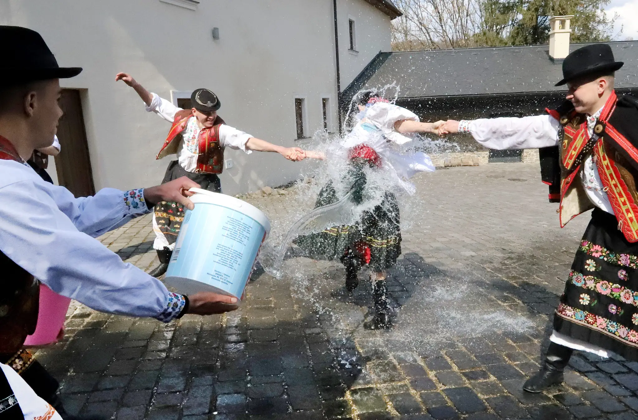 Členovia folklórneho súboru Podpoľanec z Detvy predvádzajú tradičnú veľkonočnú oblievačku na Vígľašskom zámku.