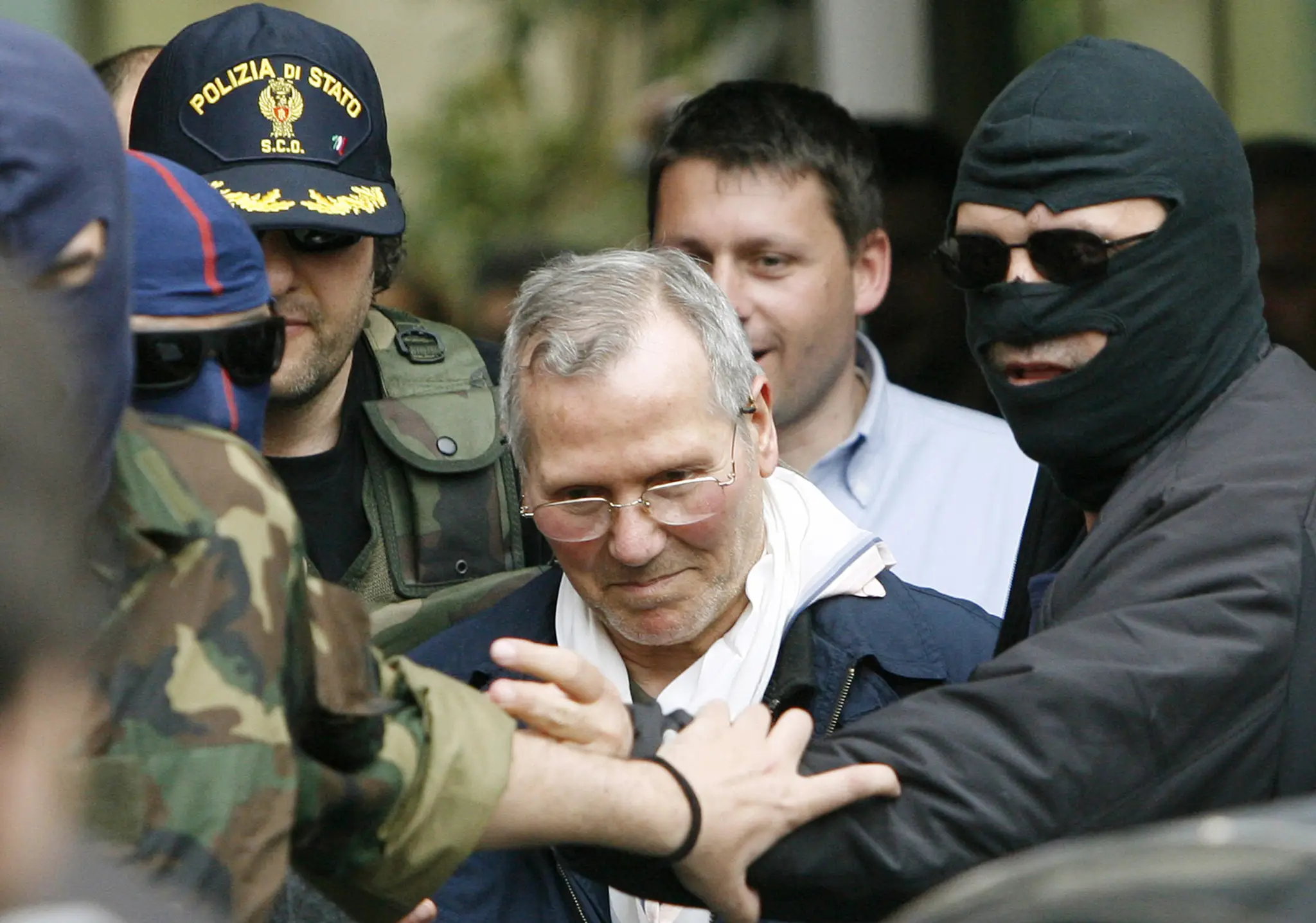 Na archívnej snímke z 11. apríla 2006 kukláči privážajú  Bernarda Provenzana na policajnú stanicu v Palerme