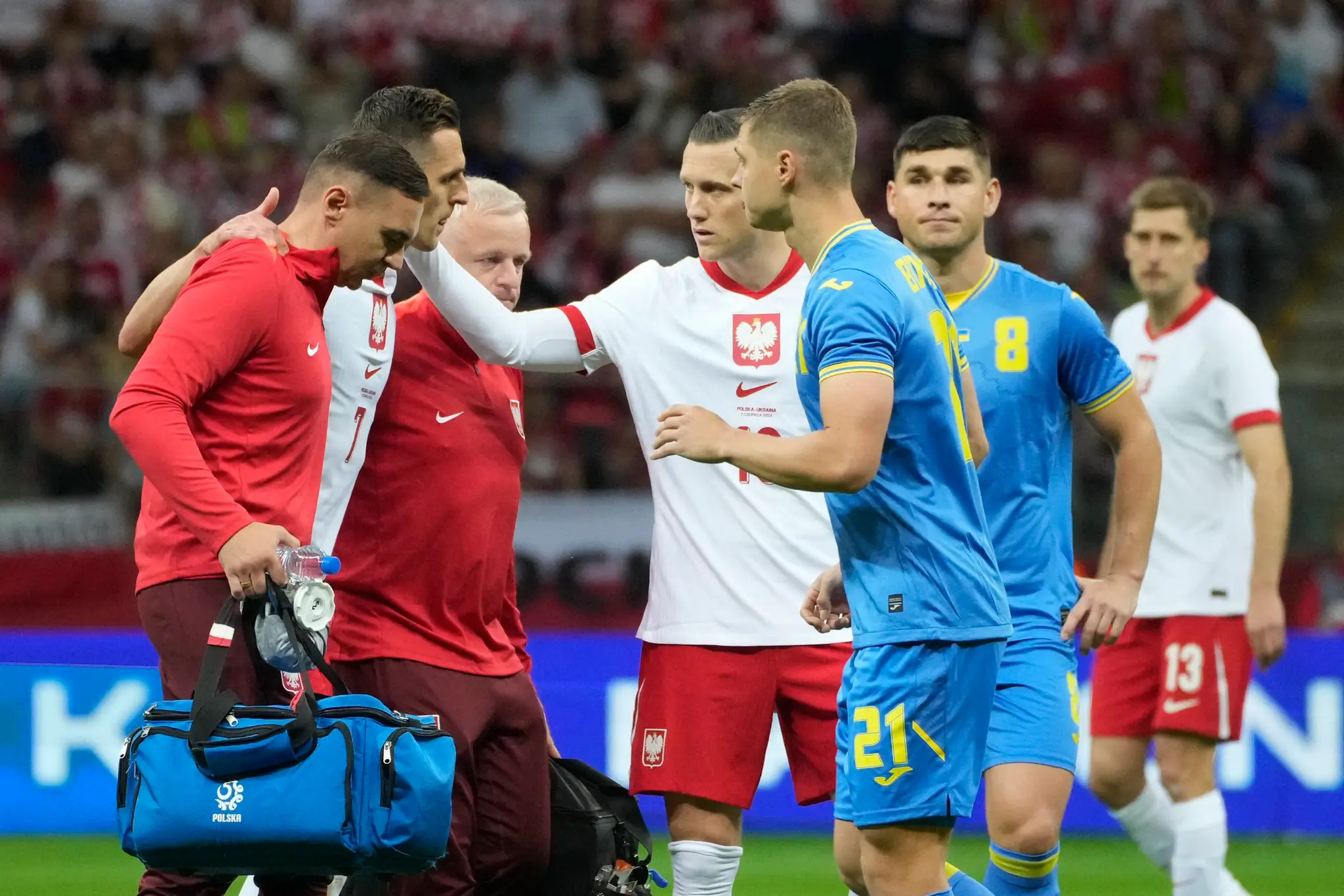 Členovia poľského tímu odnášajú zraneného Arkadiusza Milika.