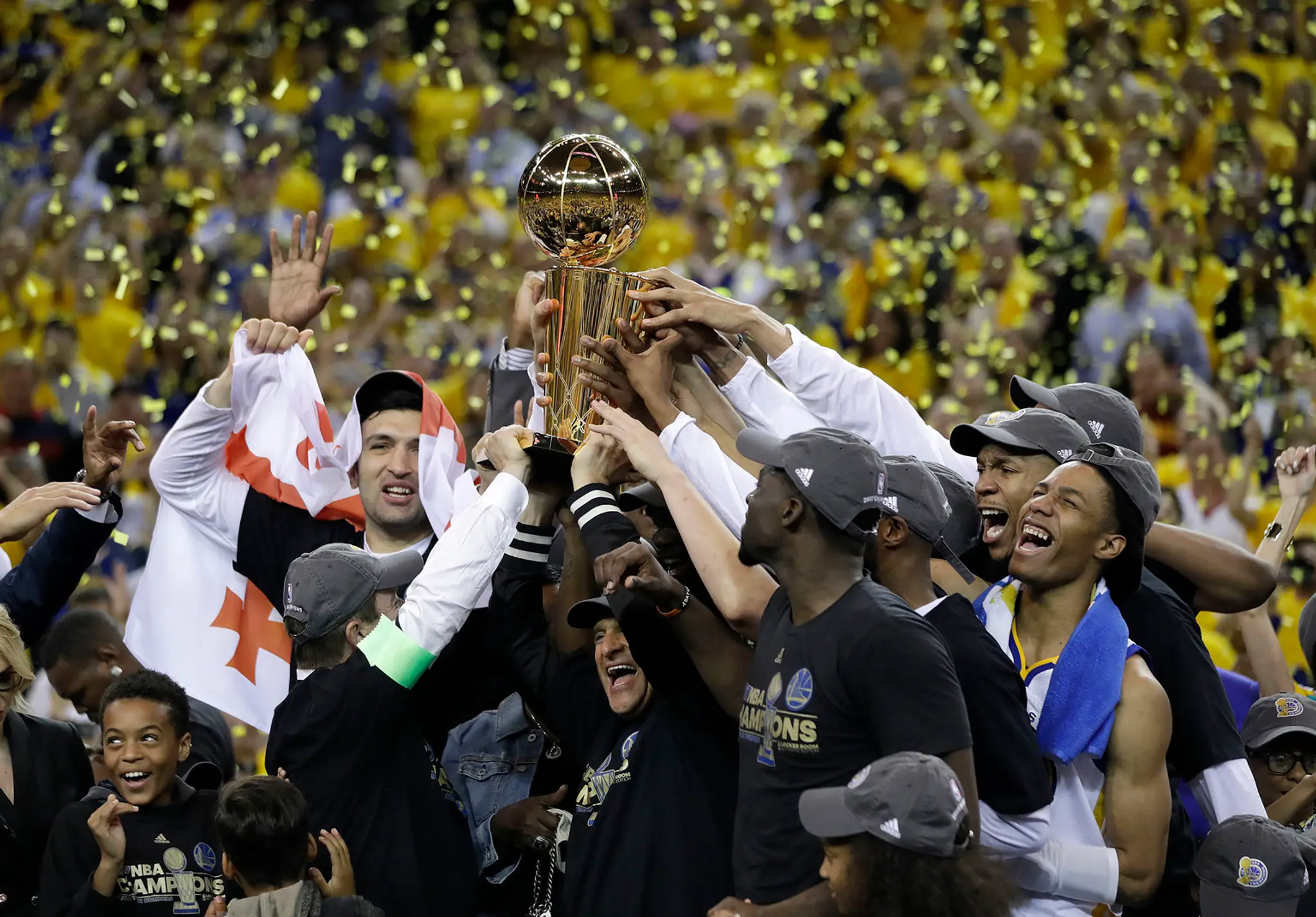 Basketbalisti Golden State Wariors s trofejou nad hlavami oslavujú víťazstvo v NBA po výhre nad Cleveland Cavaliers.