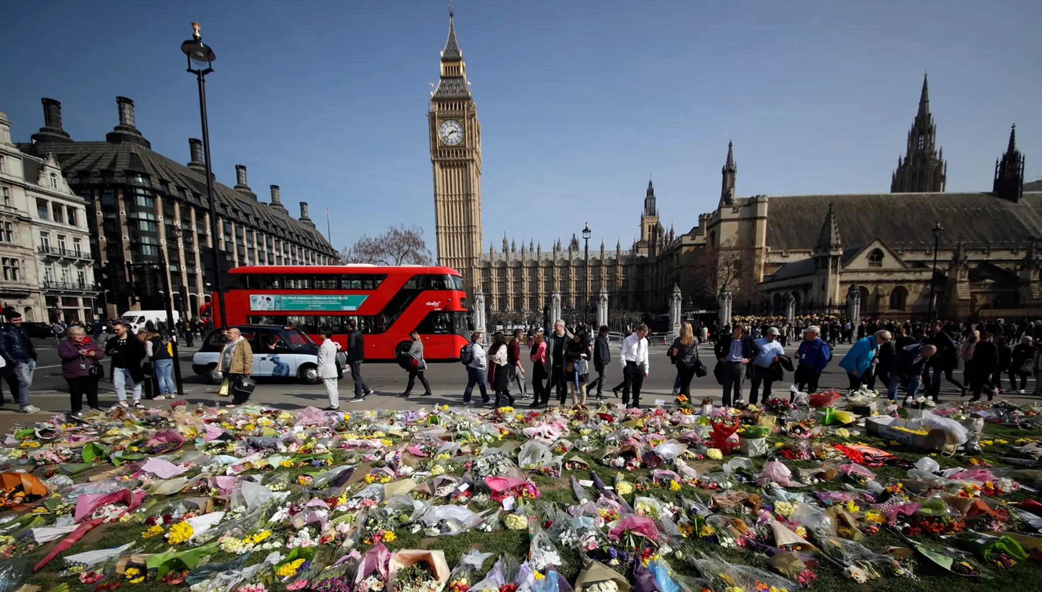 Kvety za obete teroristického útoku z 22. marca 2016 sú položené pred Westminsterským palácom 27. marca 2017 v Londýne..jpg
