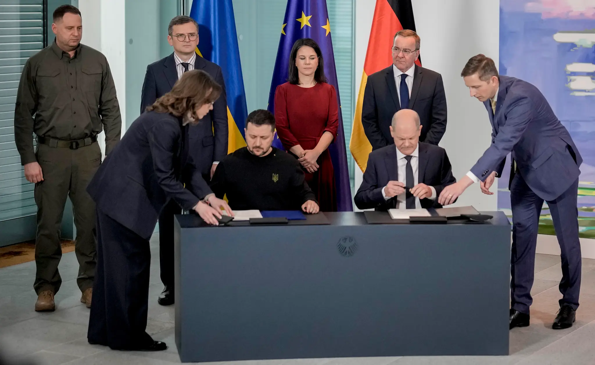 Nemecký kancelár Olaf Scholz (vpravo) a ukrajinský prezident Volodymyr Zelenskyj podpisujú bilaterálny bezpečnostný pakt 16. februára 2024 v Berlíne.