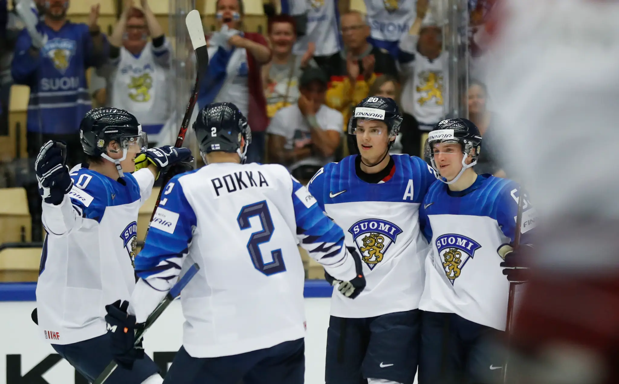Sebastian Aho (druhý sprava) oslavuje s fínskymi spoluhráčmi gól v lotyšskej sieti v dueli MS 2018.