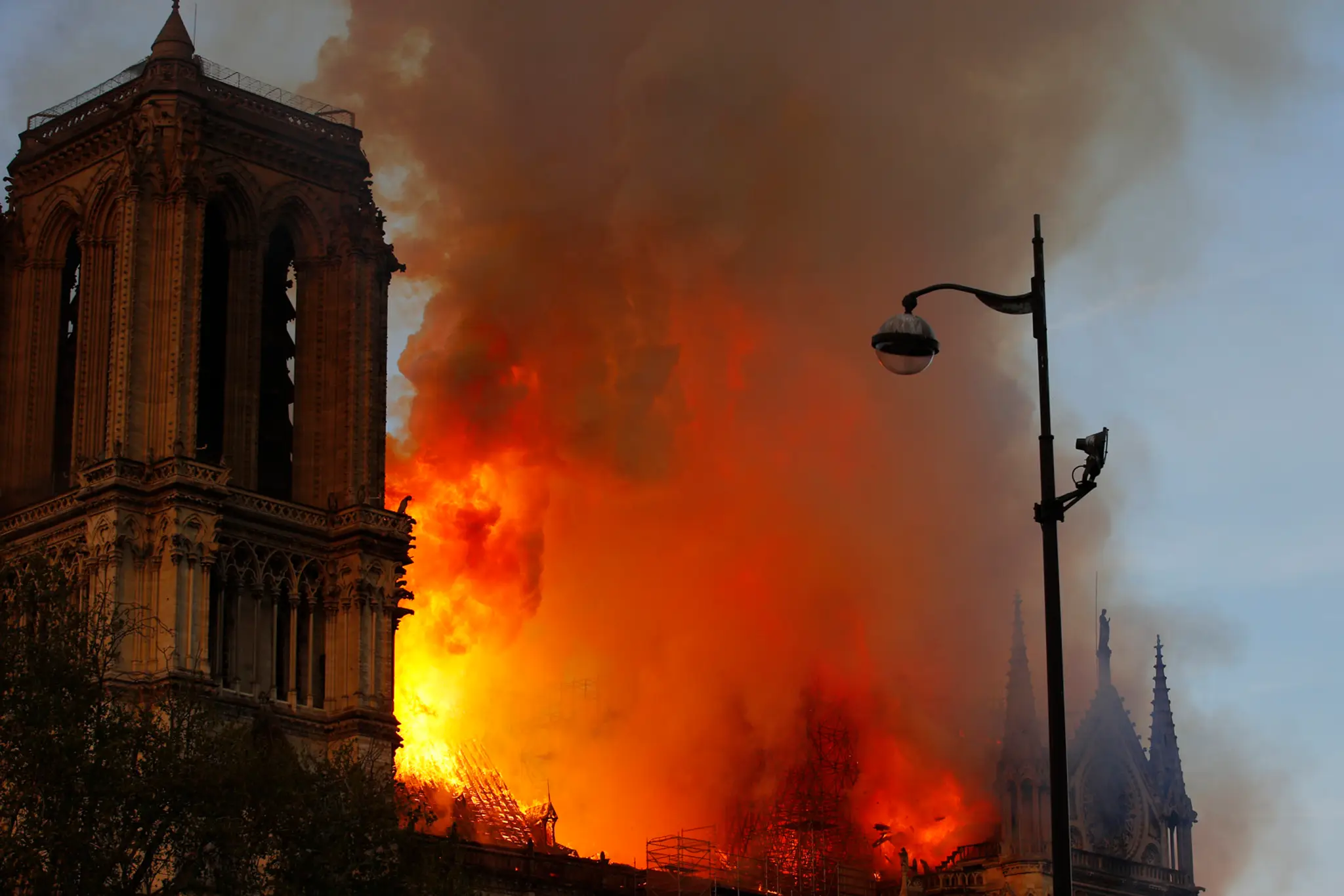 Hasič hasí požiar katedrály Notre Dame.