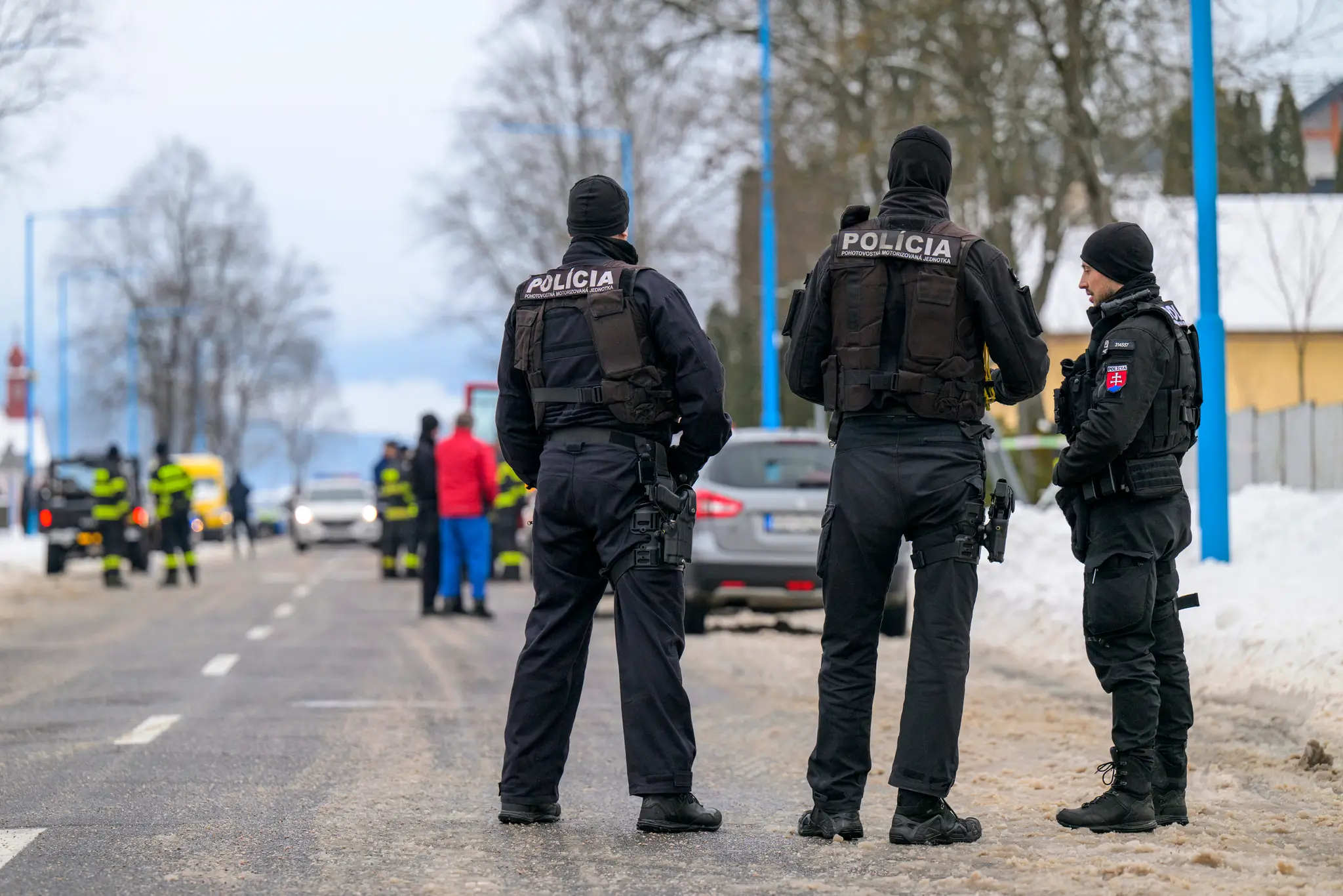 Policajti hliadkujú na ceste, ktorá vedie k budove gymnázia