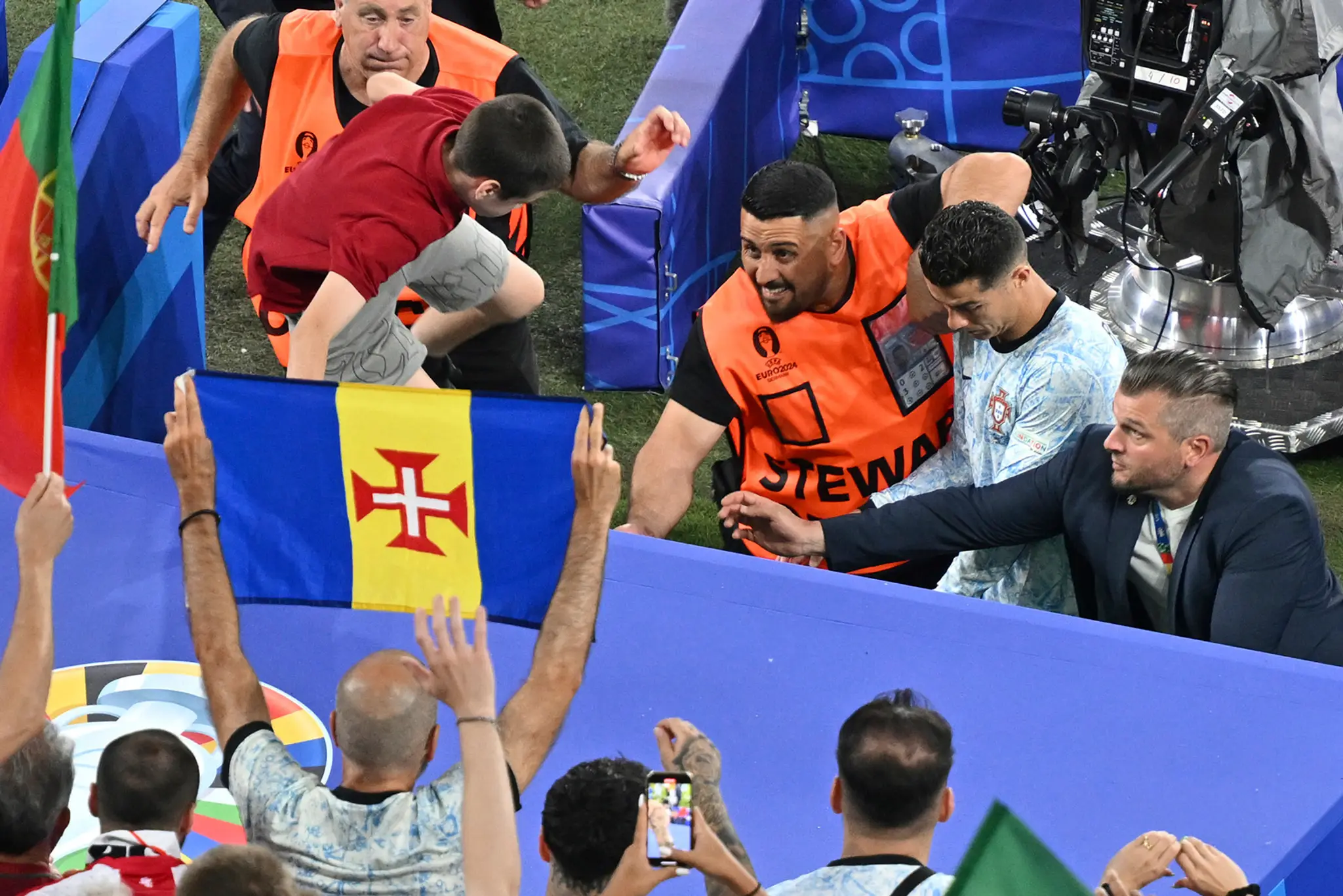 Chlapec preskakuje bariéru počas odchodu portugalského futbalistu Cristiana Ronalda z ihriska.