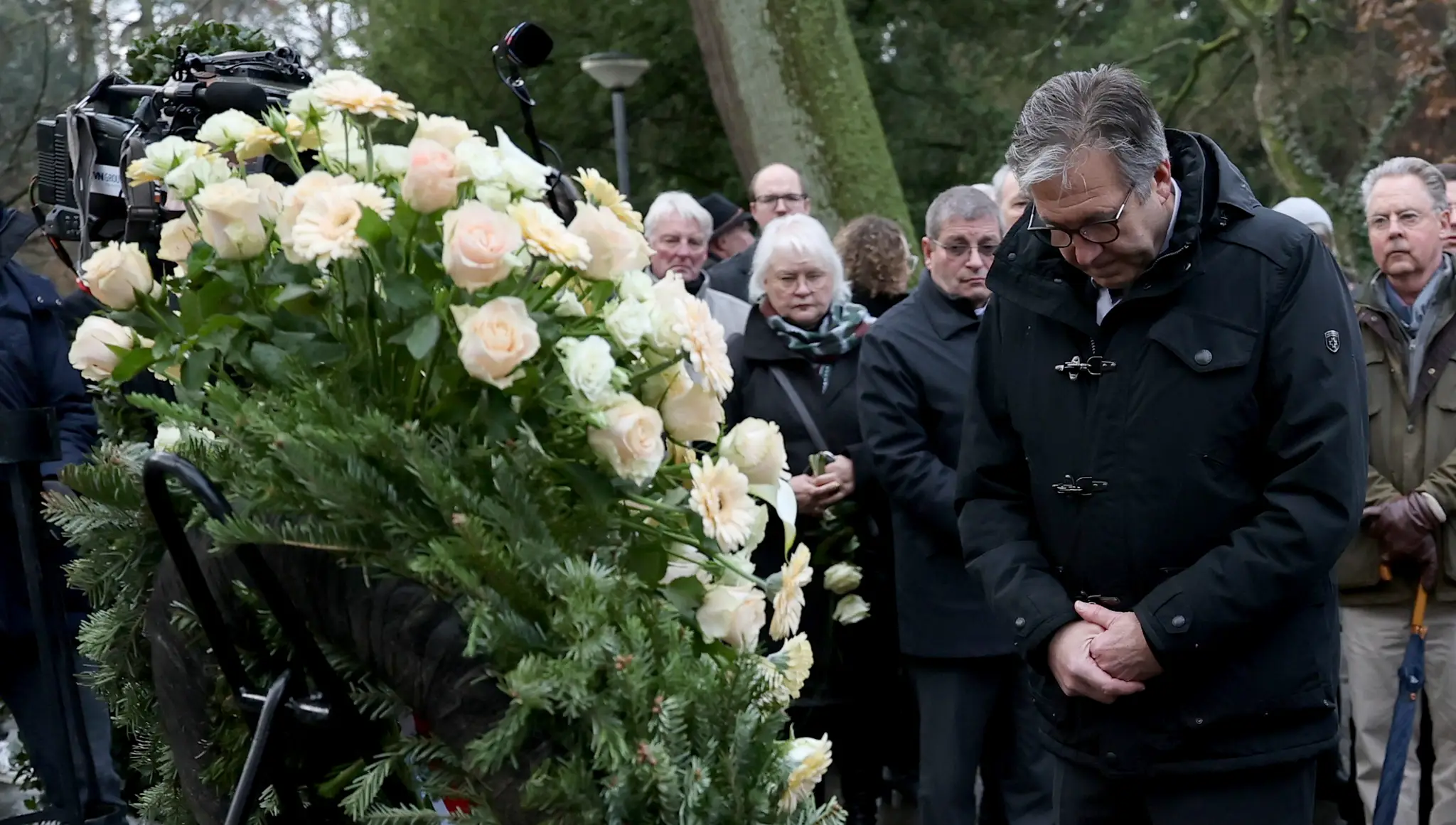 Starosta Aschaffenburgu Jürgen Herzing skláňa hlavu po položení venca po smrteľnom útoku v parku.