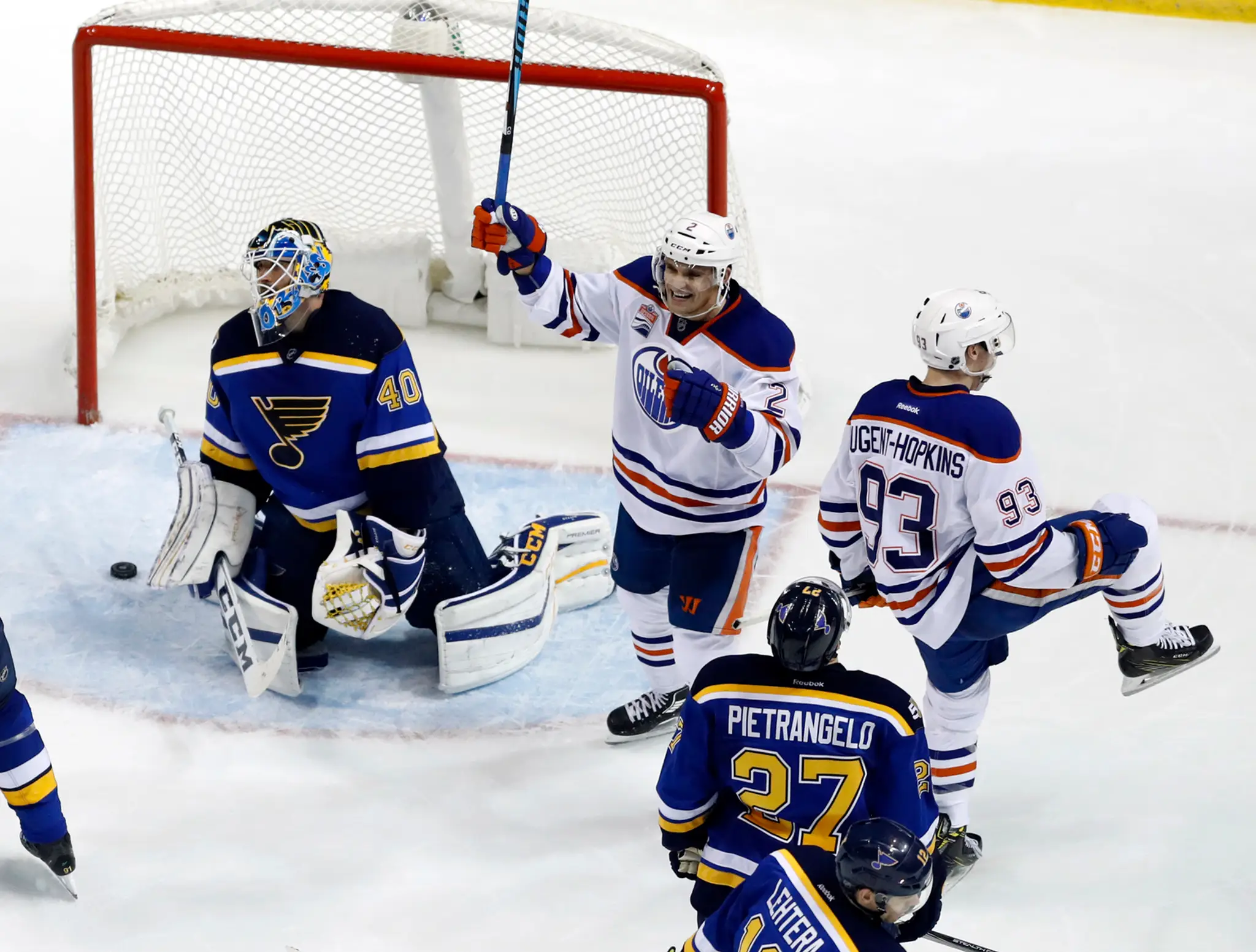 Hokejisti Edmontonu Oilers Ryan Nugent-Hopkins (93) a Slovák Andrej Sekera (druhý zľava) sa tešia po strelení víťazného gólu.