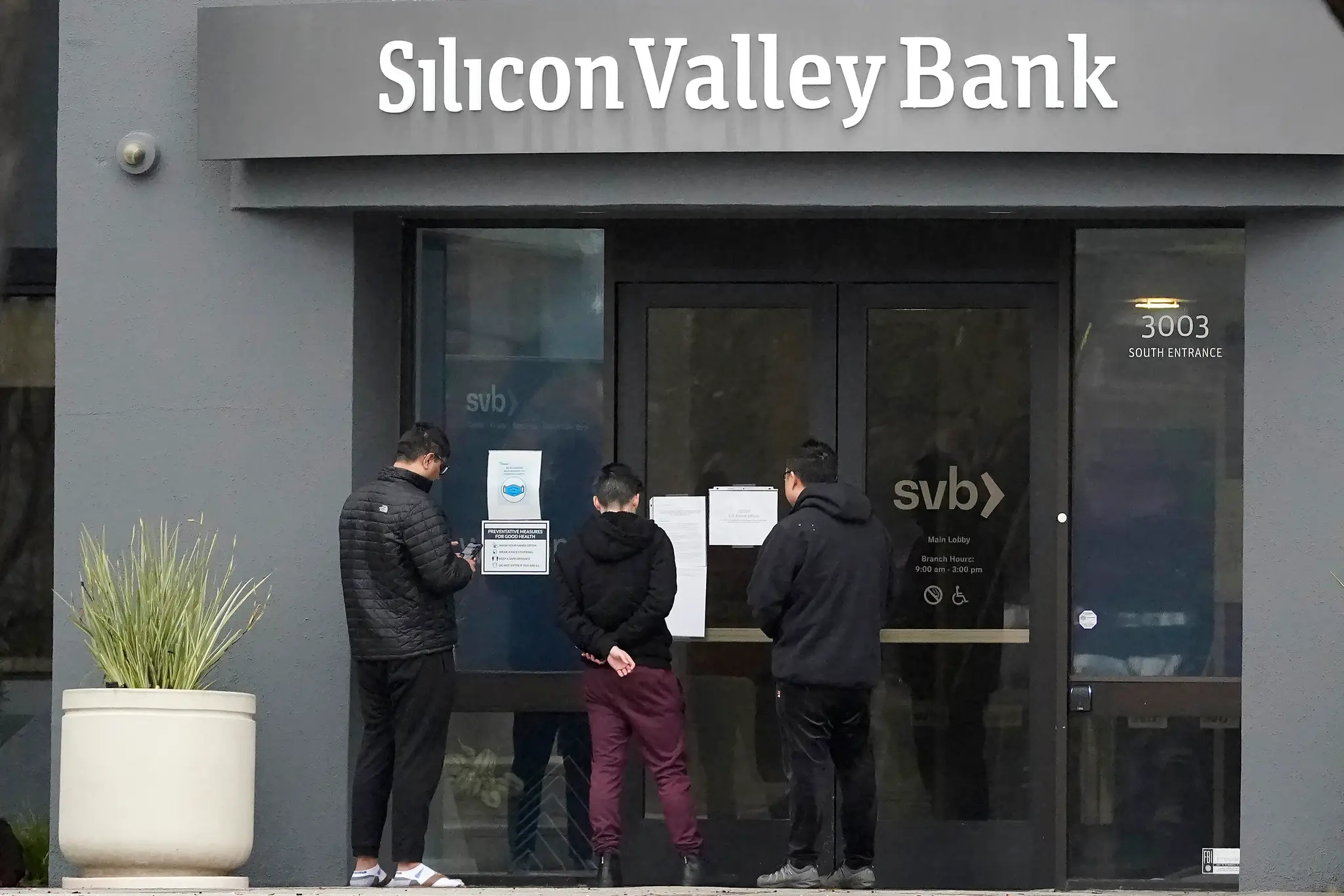Ľudia si čítajú oznam pred vchodom do banky Silicon Valley Bank