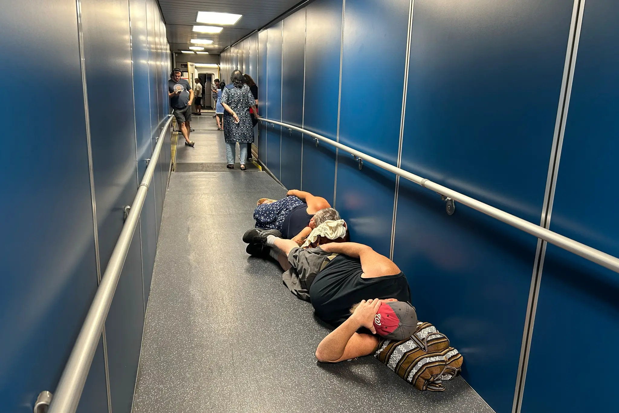 Na snímke cestujúci na medzinárodnom letisku spia v odletovej hale pre meškajúci let spoločnosti United Airlines po rozsiahlom výpadku internetu vo svete.